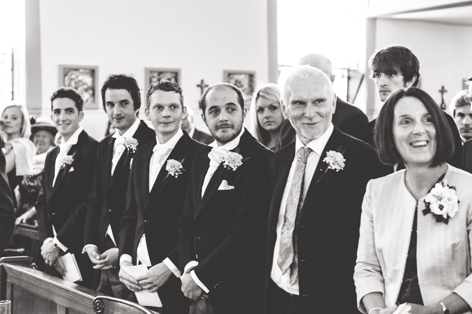Ushers watch bride as she walks up aisle