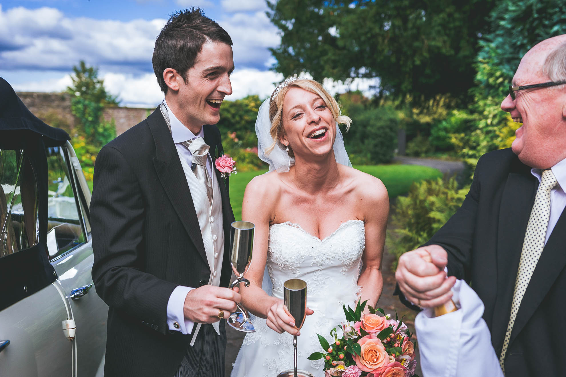 Bride and groom share a joke with chauffer
