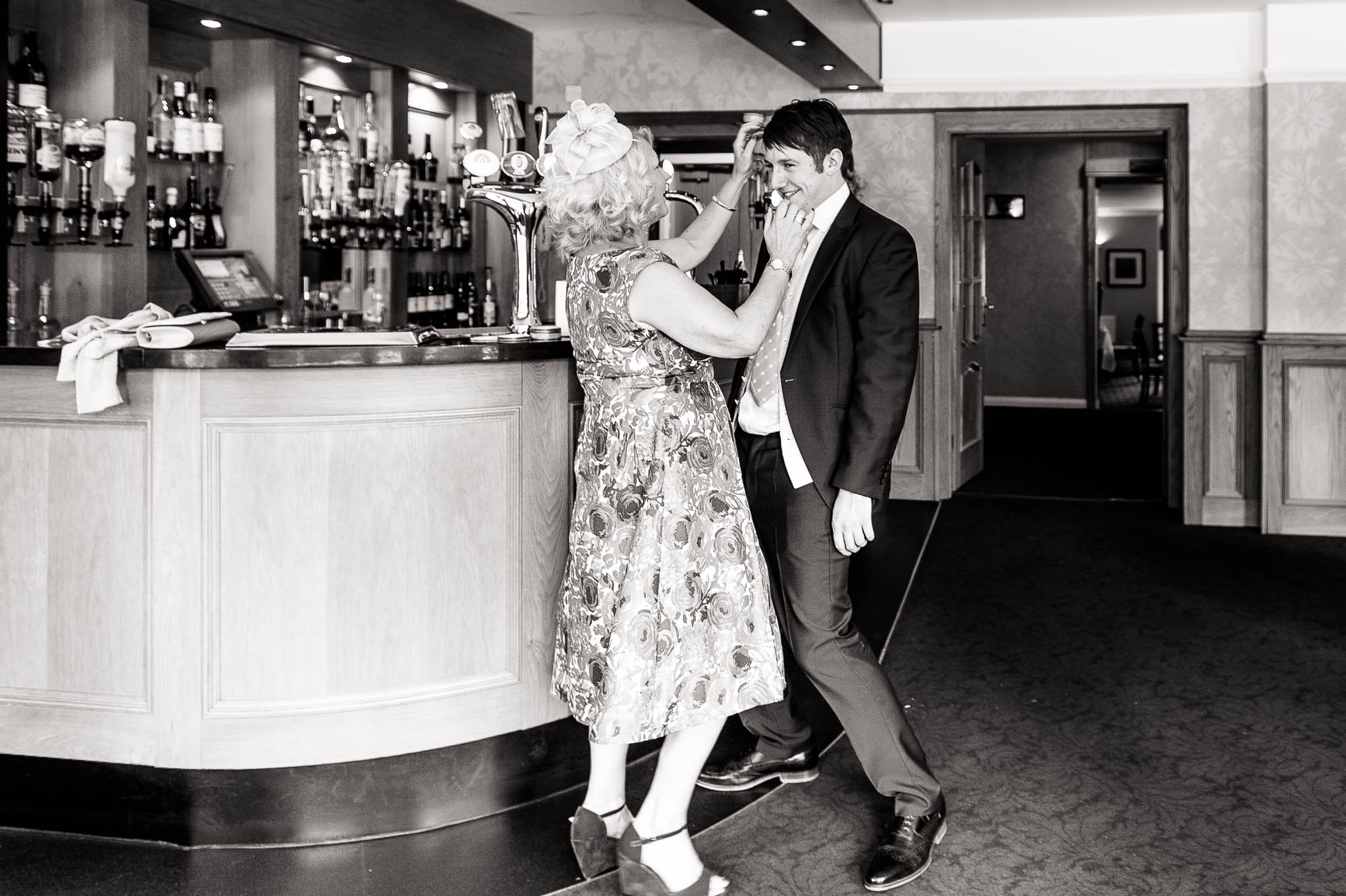 Mother of the bride adjusting grooms hair