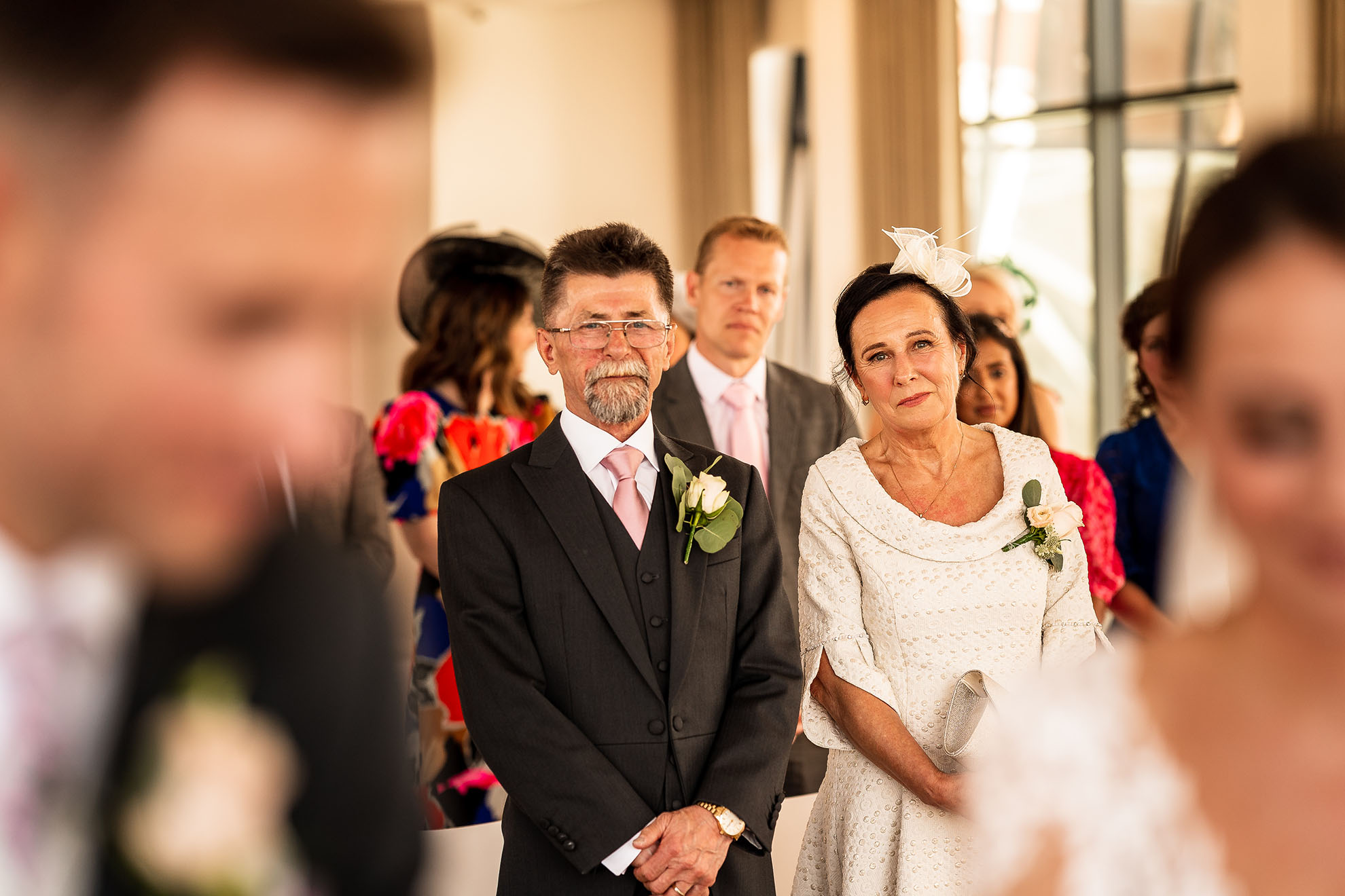 Mother and father of the bride watch the happy couples exchange of rings