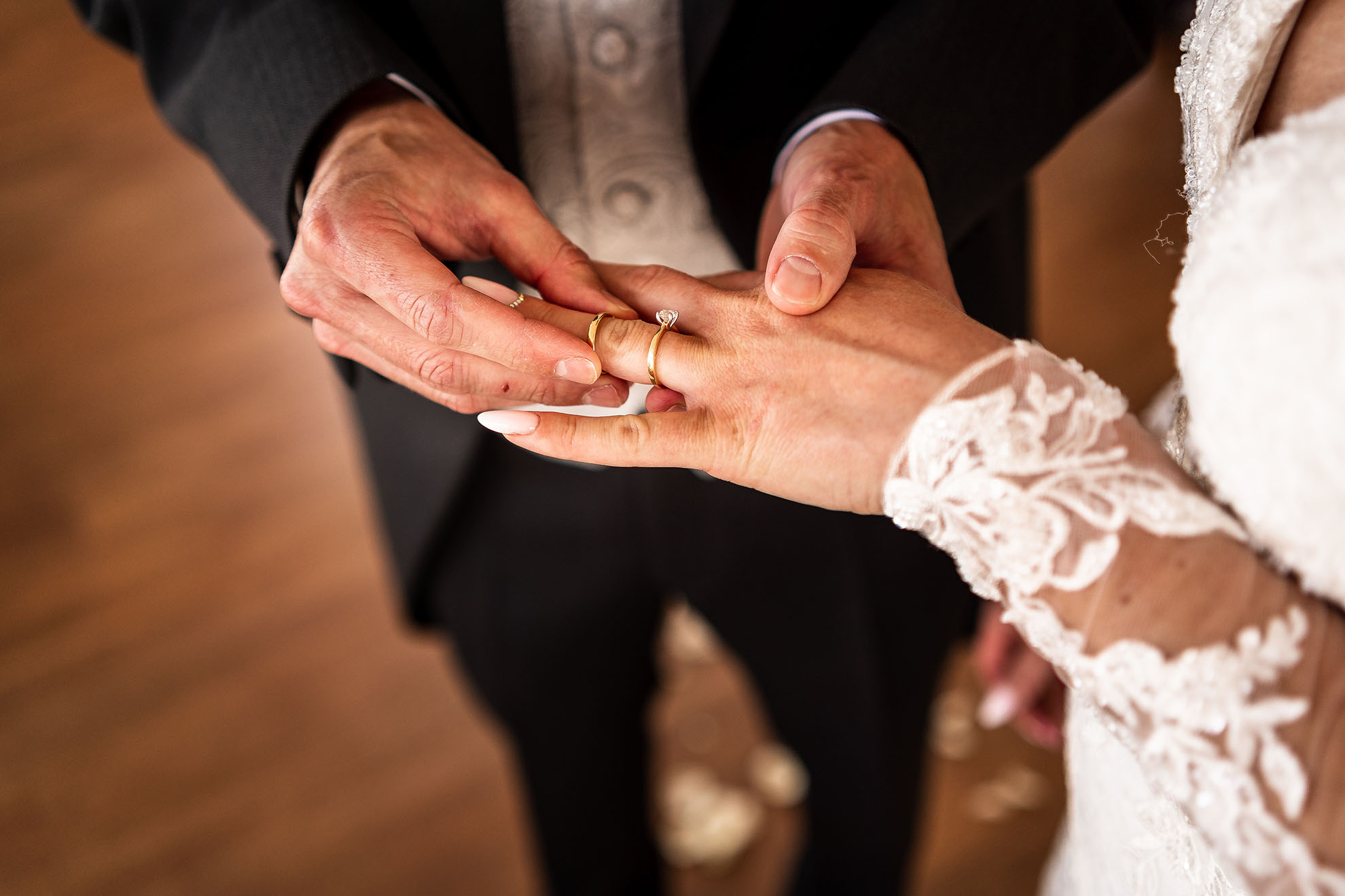Groom places the wedding ring on brides finger