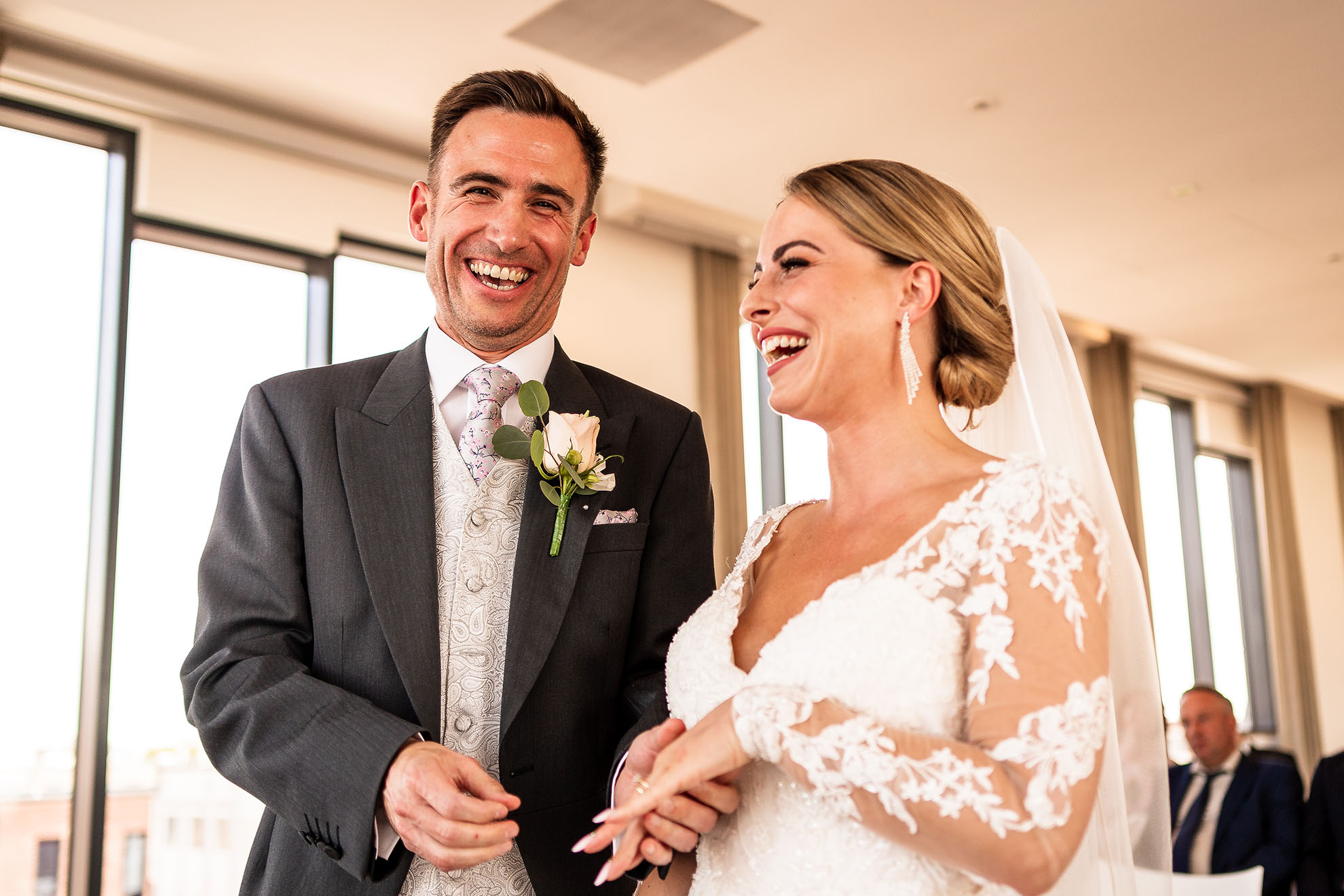 Bride and groom share a joke during exchange of rings