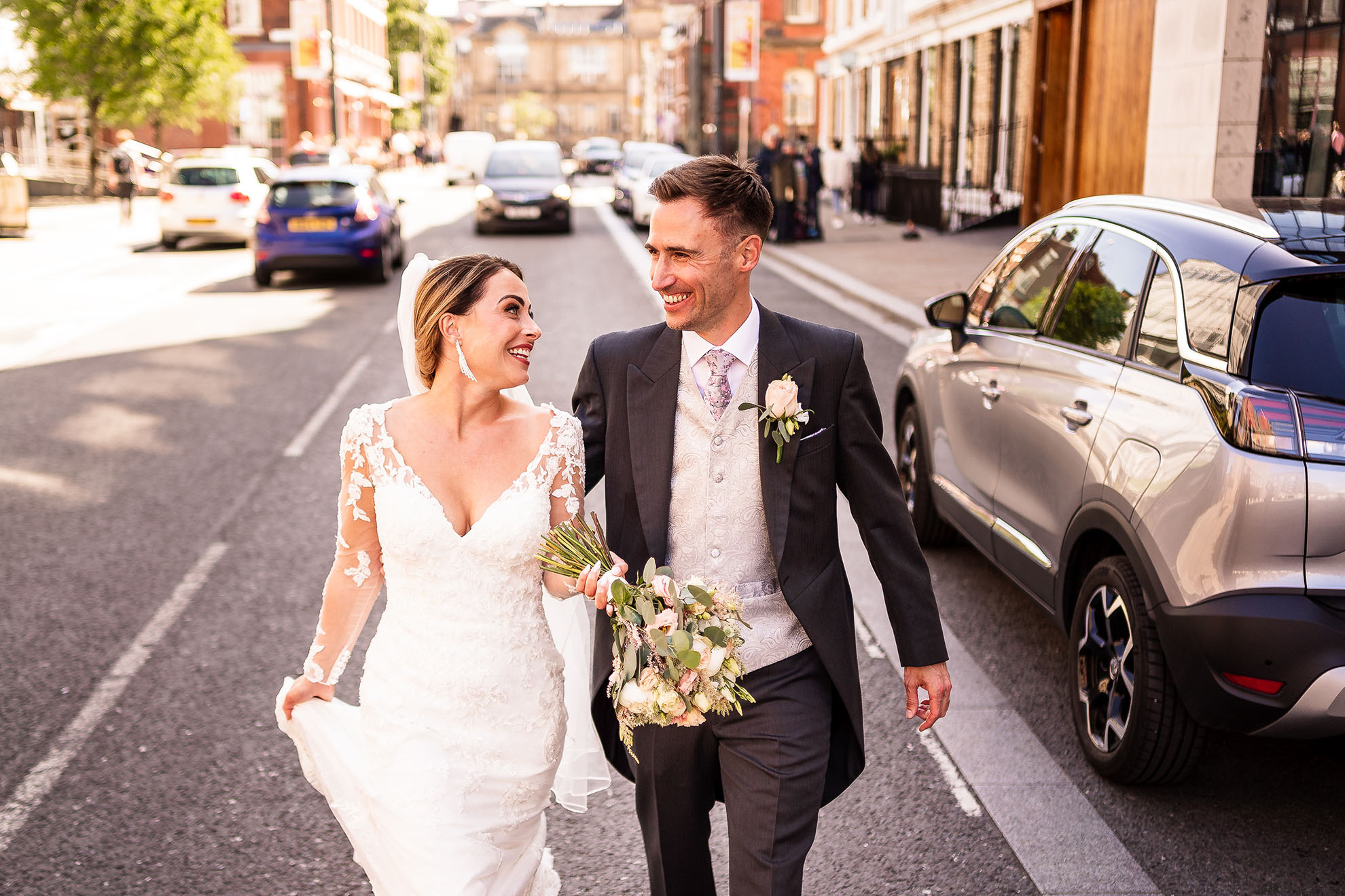 Bridea and groom laugh as they walk down Hope Street