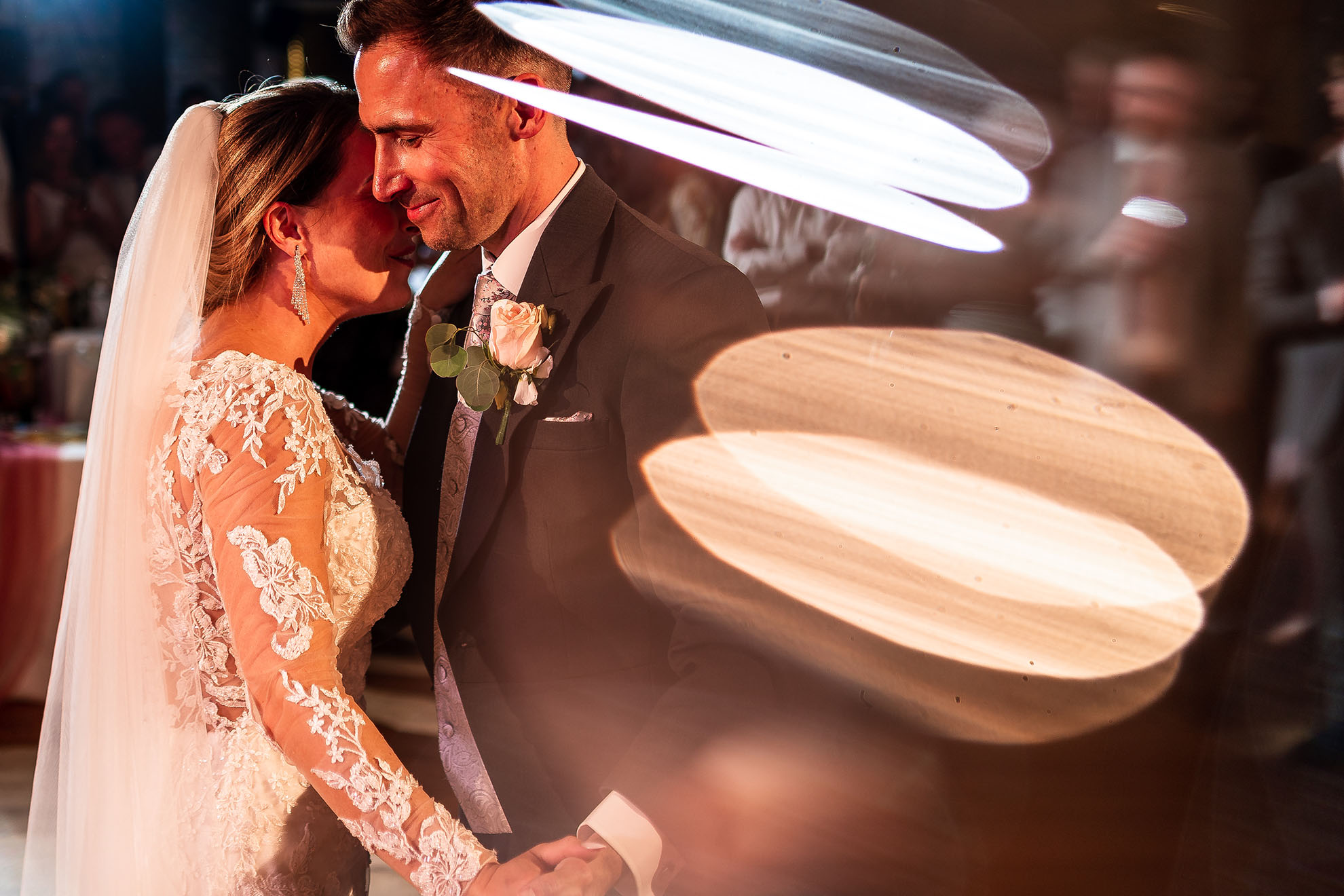 Bride and groom hold each other close during the first dance