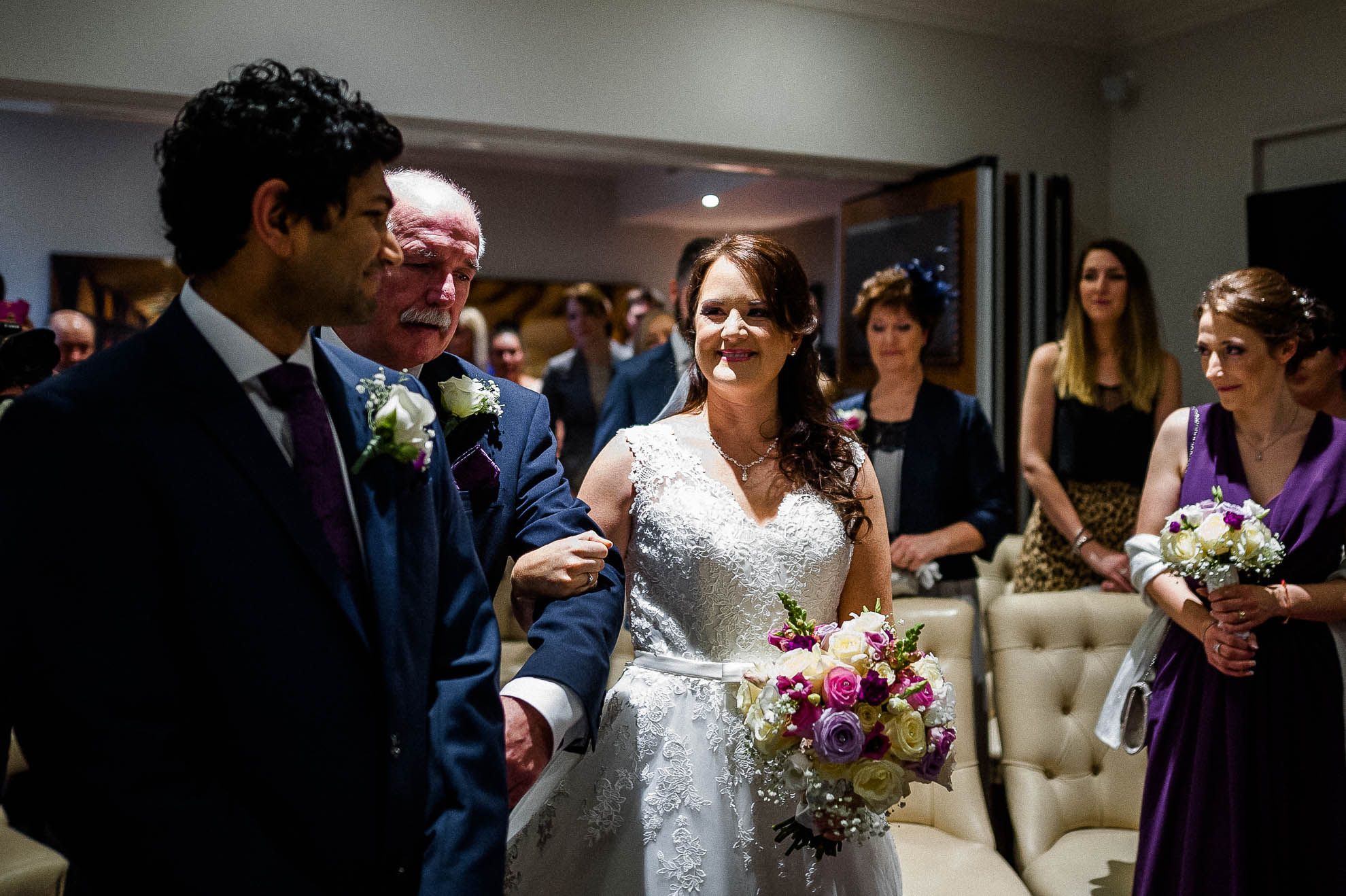bride and groom smile at each other as the bride arrives 