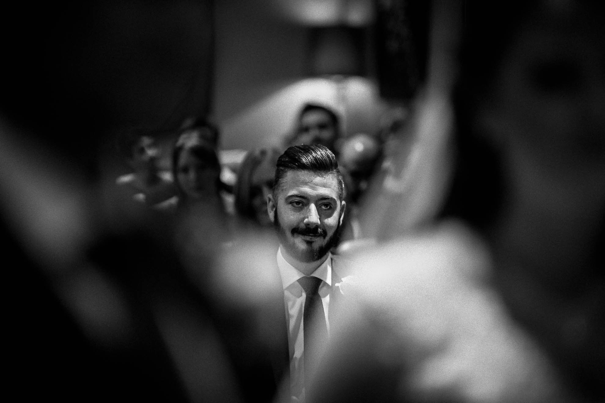 Brides brother smiles during the exchange of rings