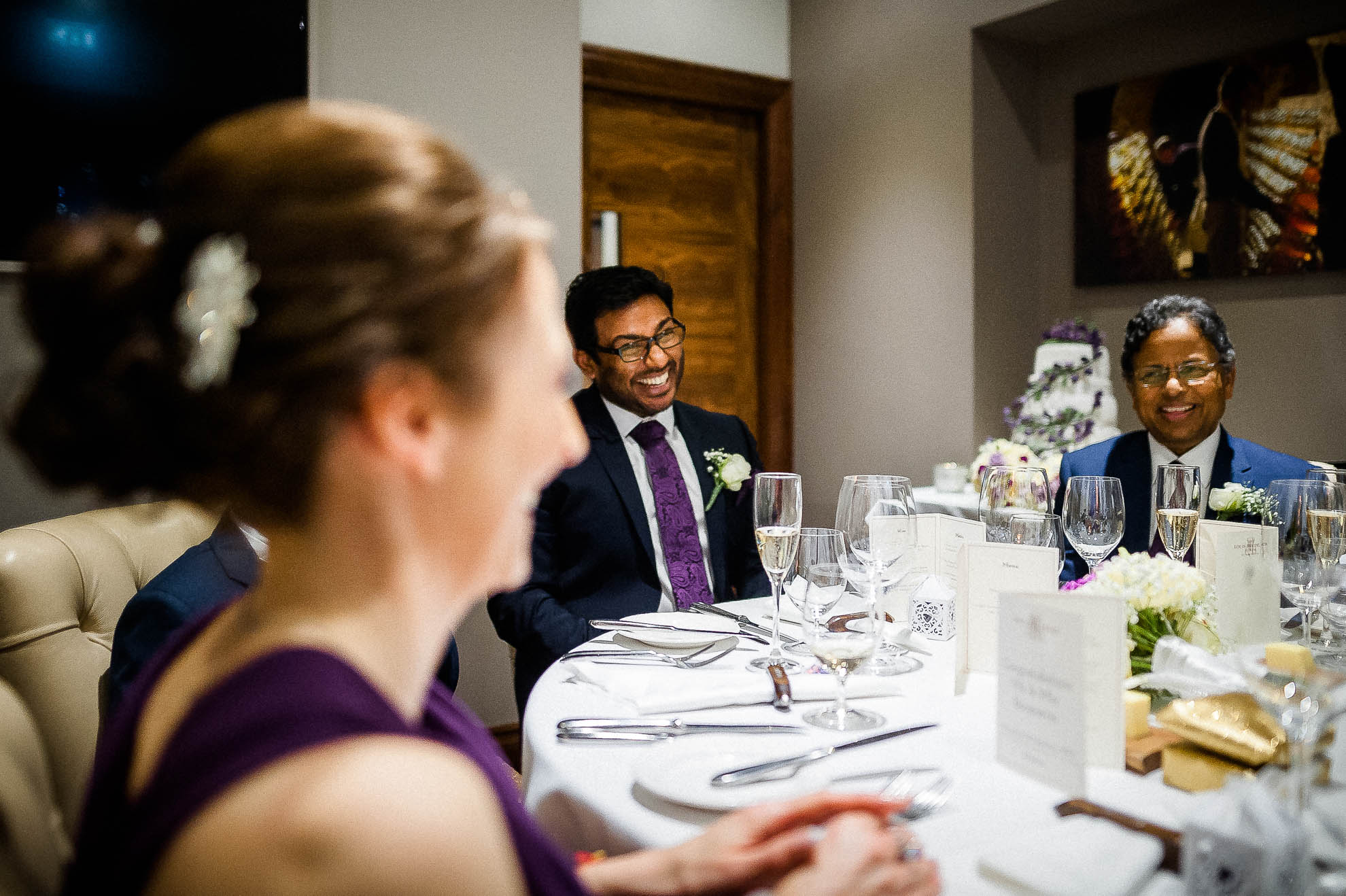 Groom's brother laughs at a joke during speeches