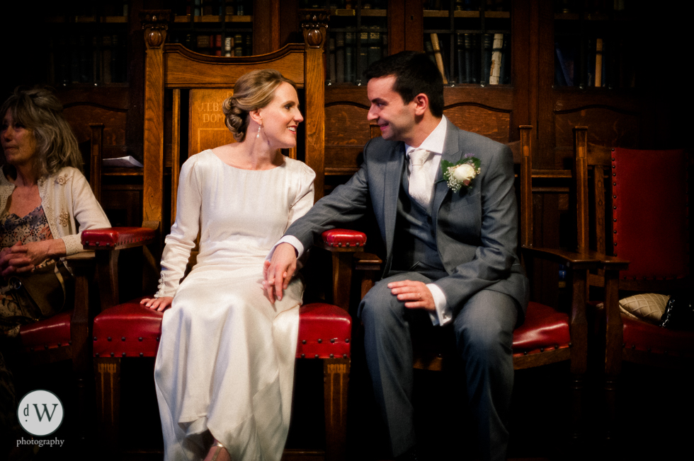 Bride and groom holding hands sitting down