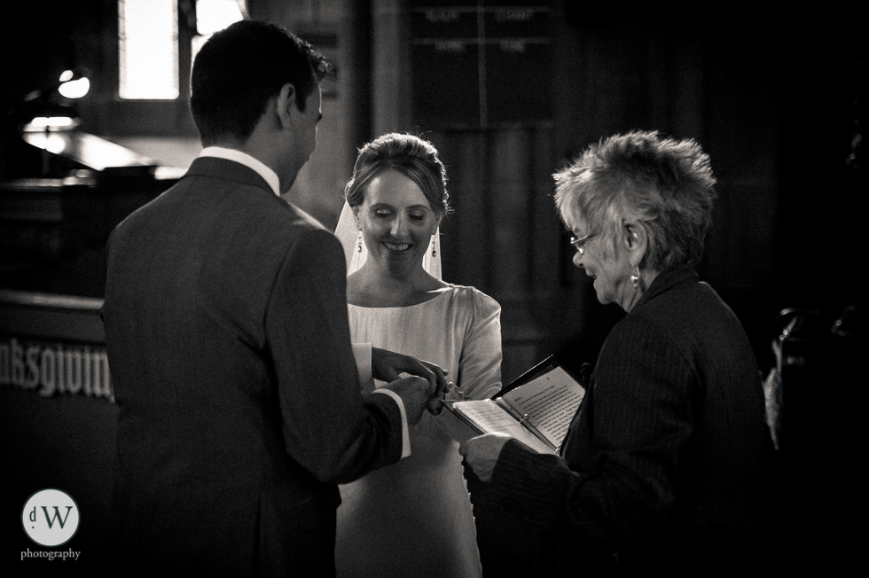 Groom places wedding ring on brides hand