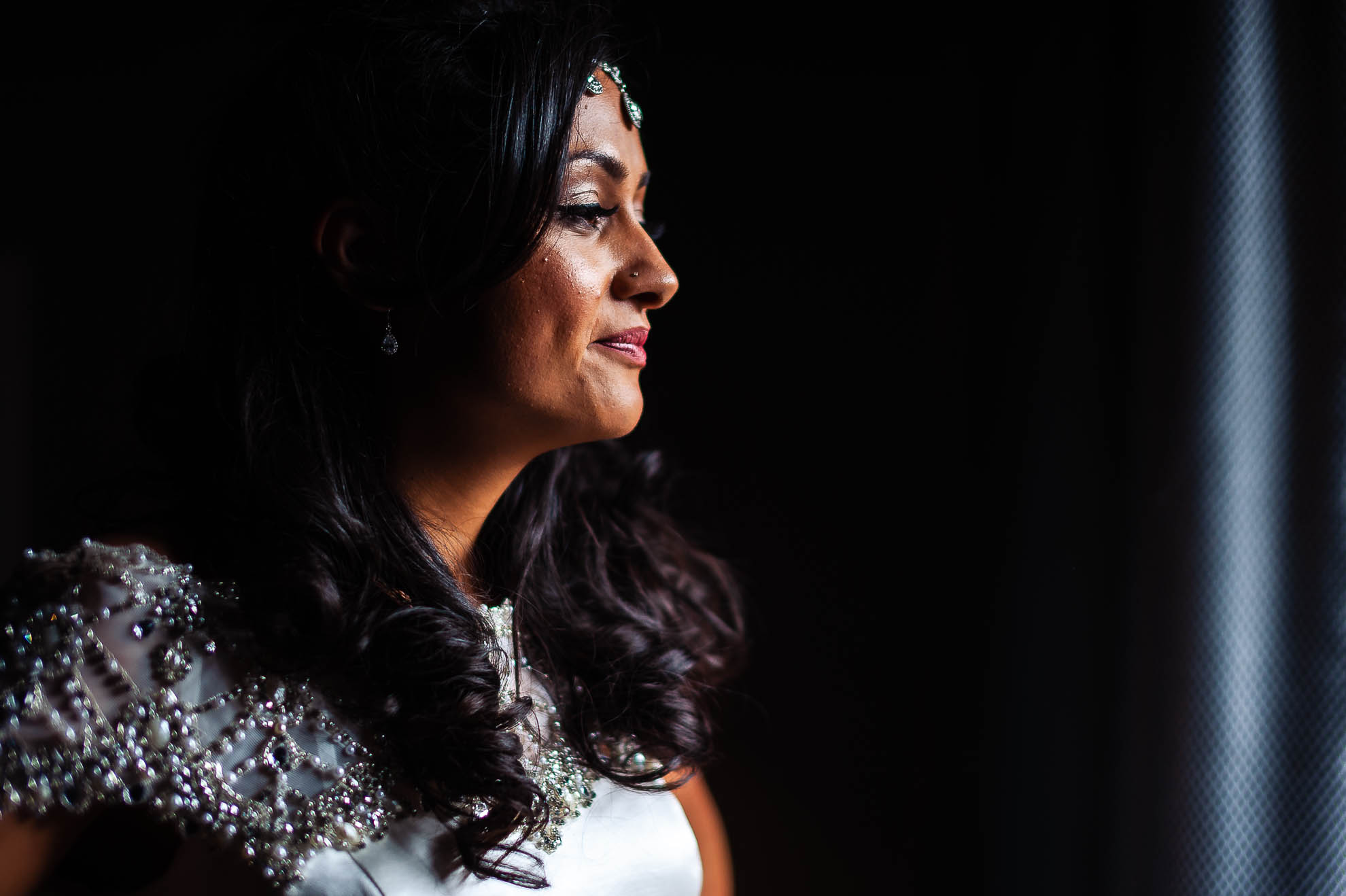 Bride smiles as she is helped into her dress