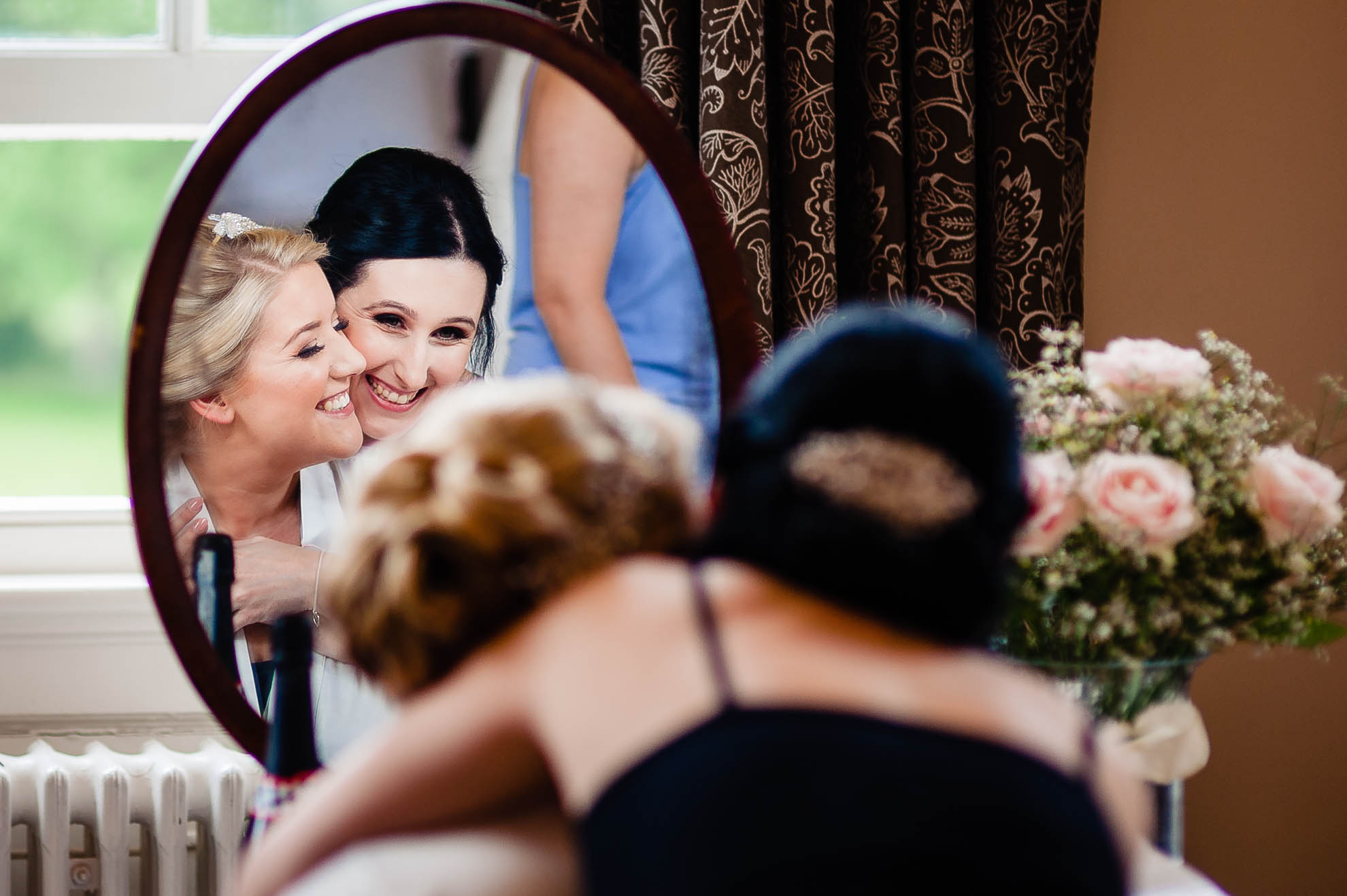 Bride gets a hug from a bridesmaid during the bridal preparations