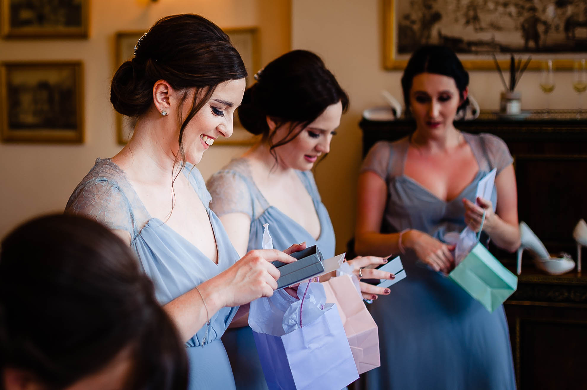 Bridesmaid smiling as she opens her present