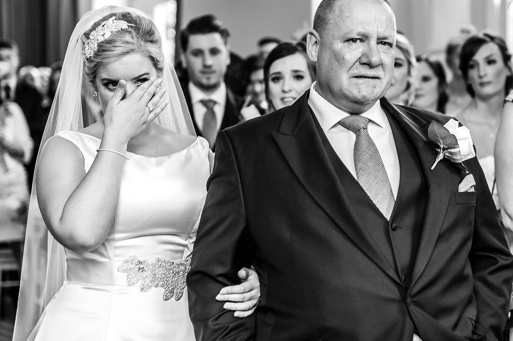 Bride wipes away a tear as she arrives at the ceremony