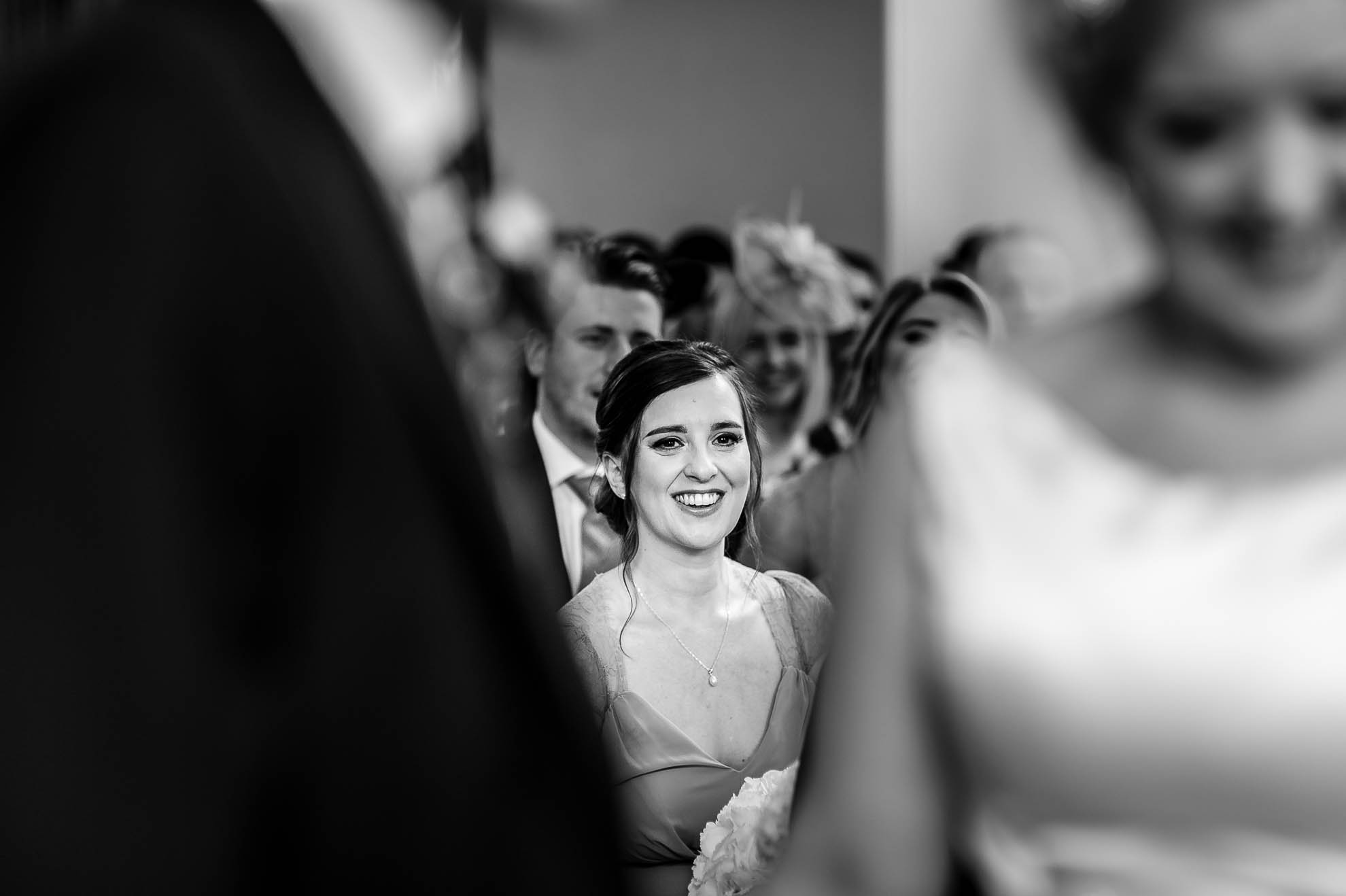 Bridesmaid smiles as she watches the ceremony