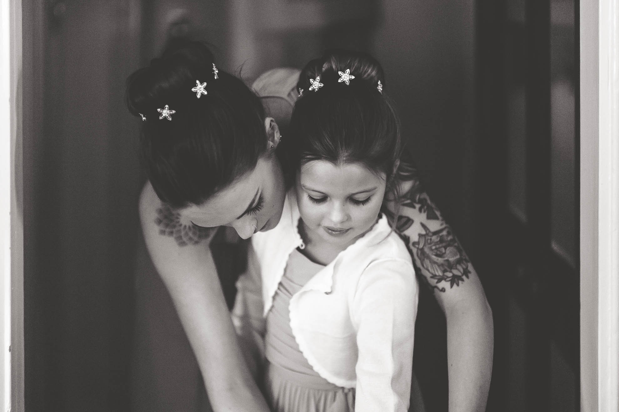 Bridesmaid helps flower girl get ready