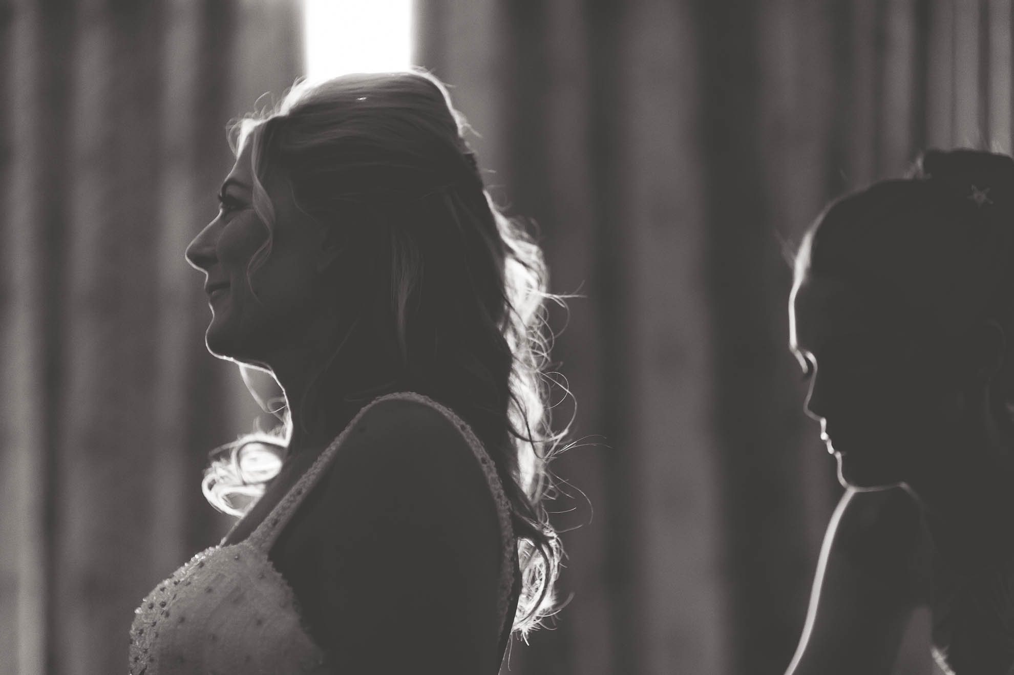 Bride being helped into her wedding dress by bridesmaid