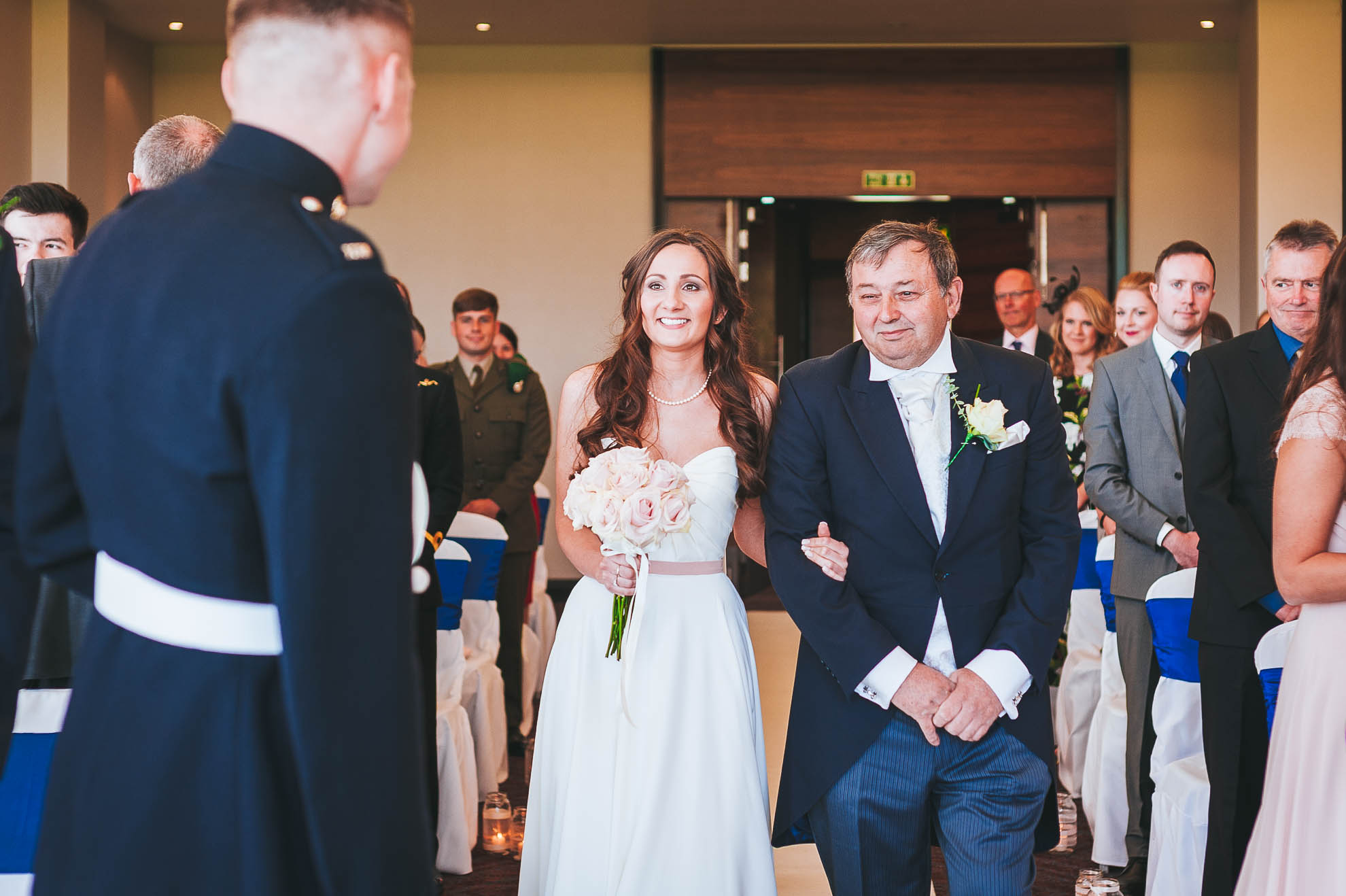 Bride and groom greet each other as bride walks up the ailse