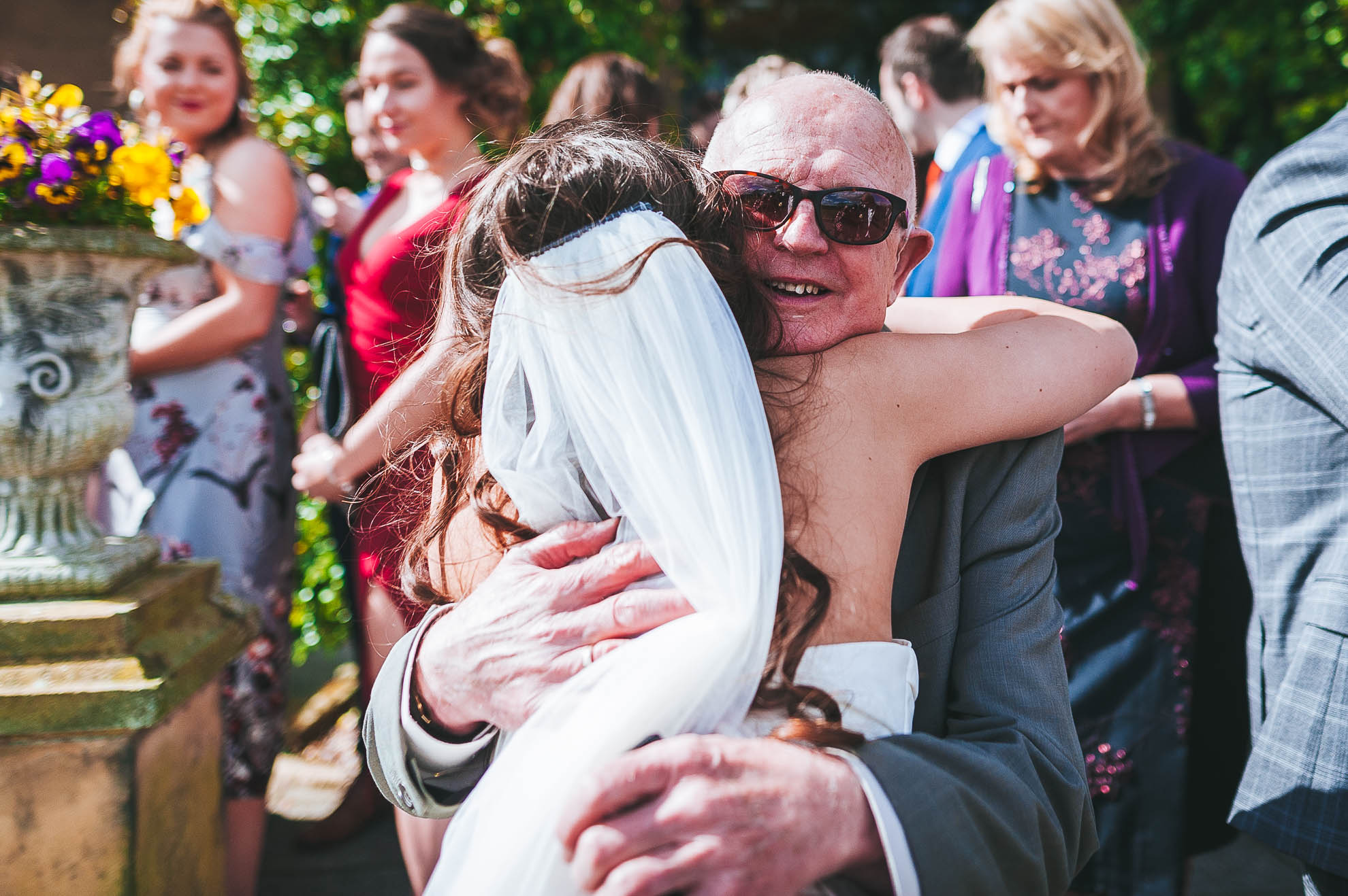 Guest hugs the bride at the drinks reception