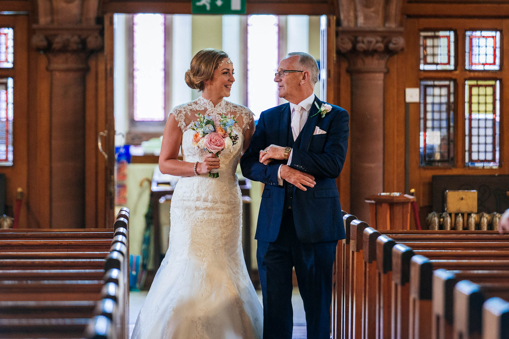 bride and her dad look at each other before they walk down the aisle.