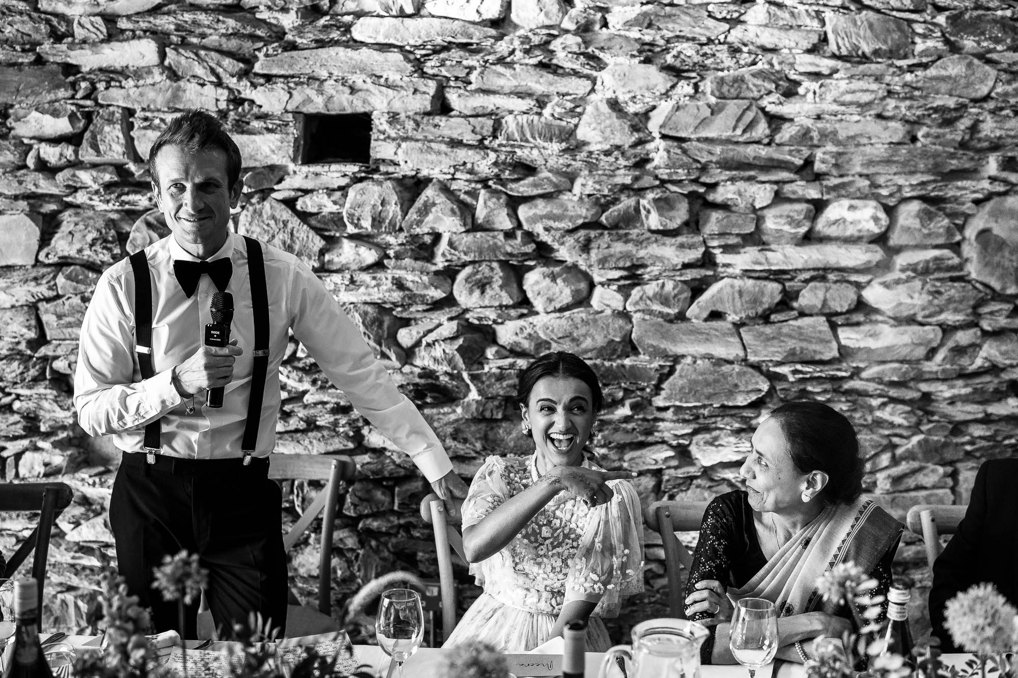 The bride laughs during the groom's speech