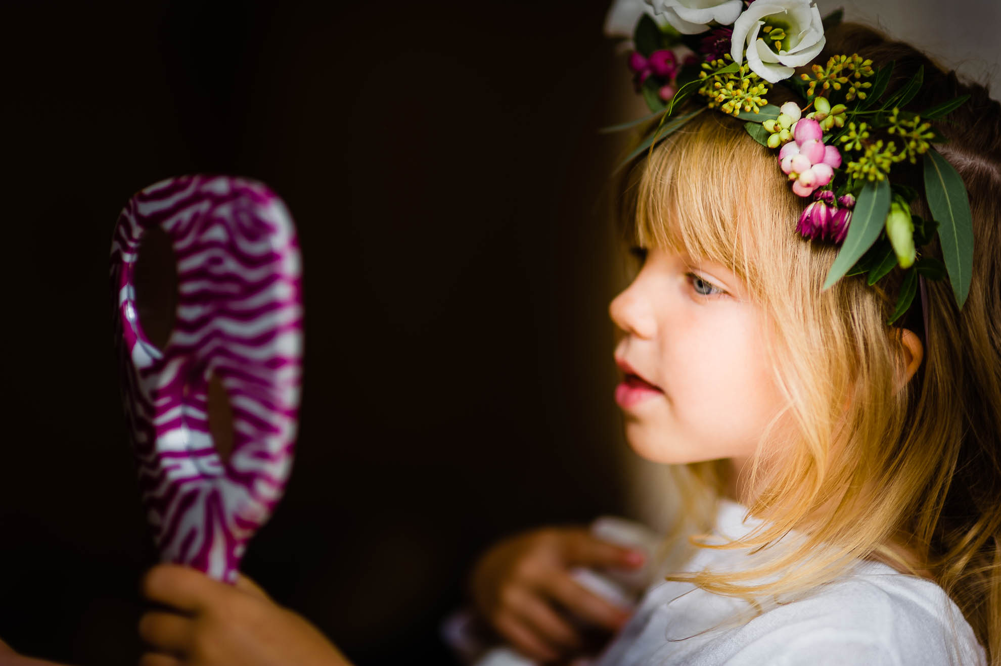 flower girl looks in mirror