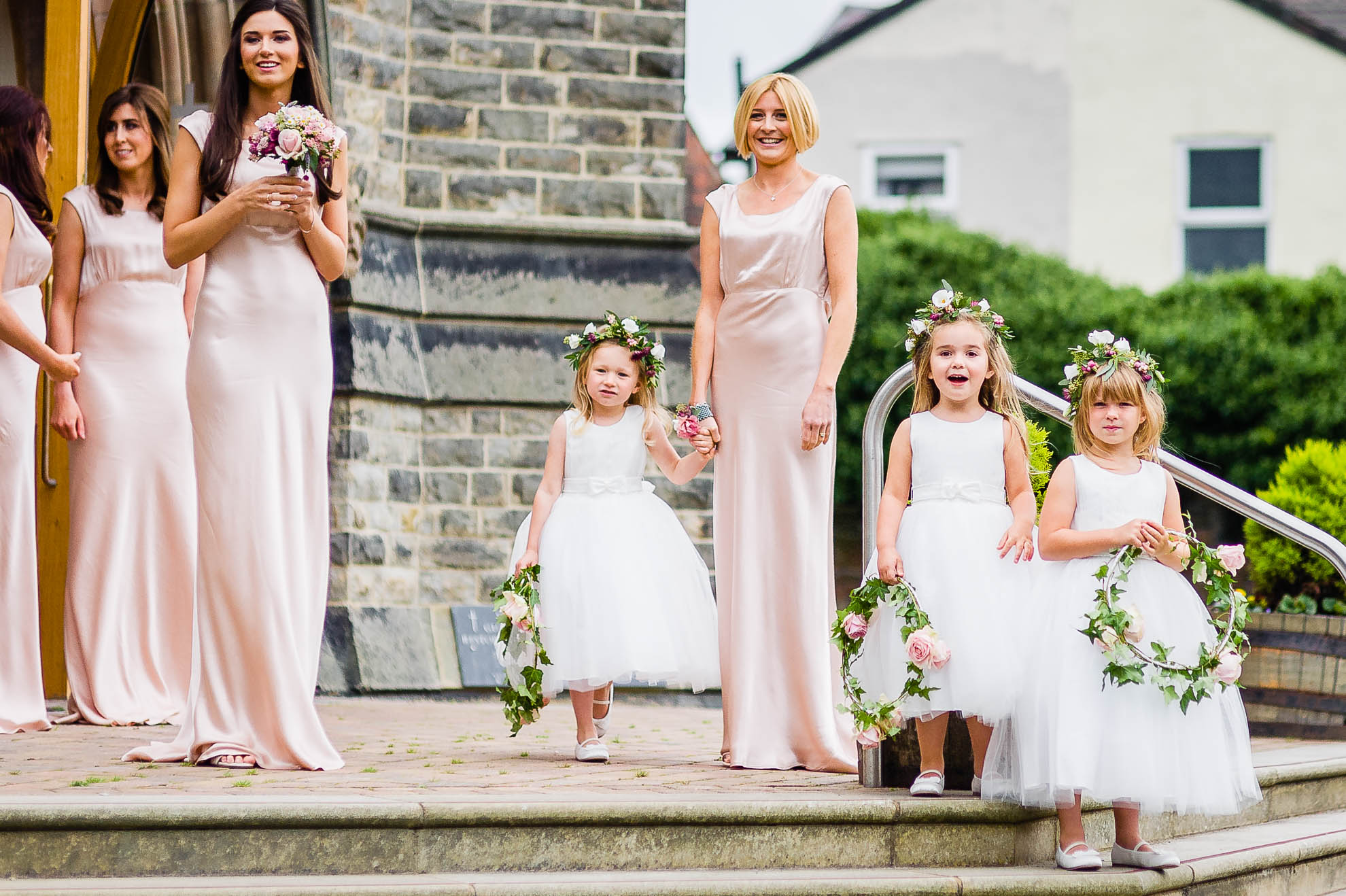 The bridesmaids look on and smile as the bride arrives