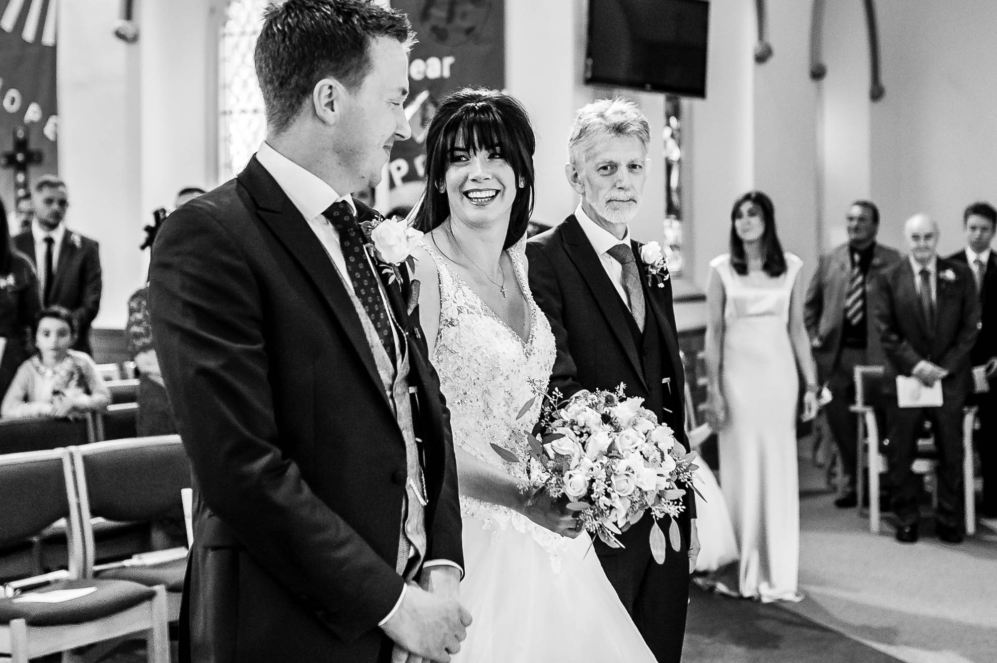 Bride gives the groom a big smile as she arrives at the altar