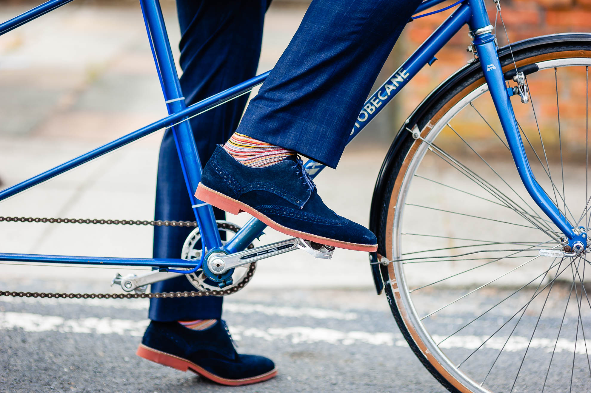 Grooms foot on pedal of tandem cycle