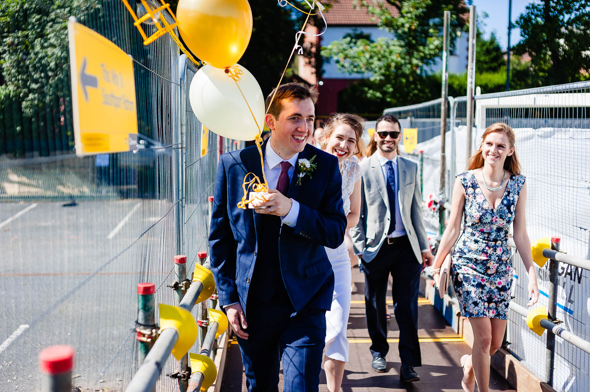 Groom holding balloons