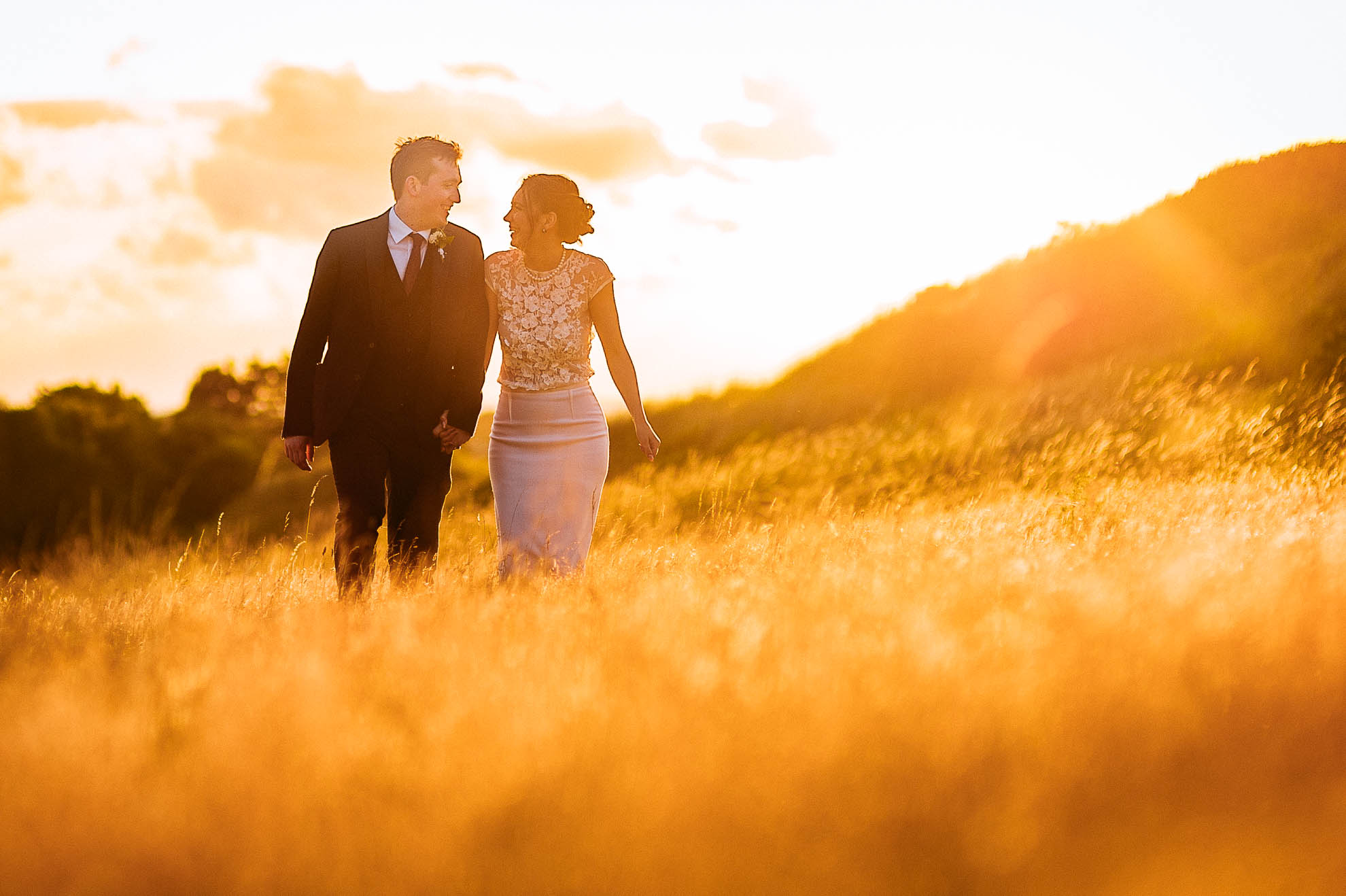 Newlyweds walking in sunset