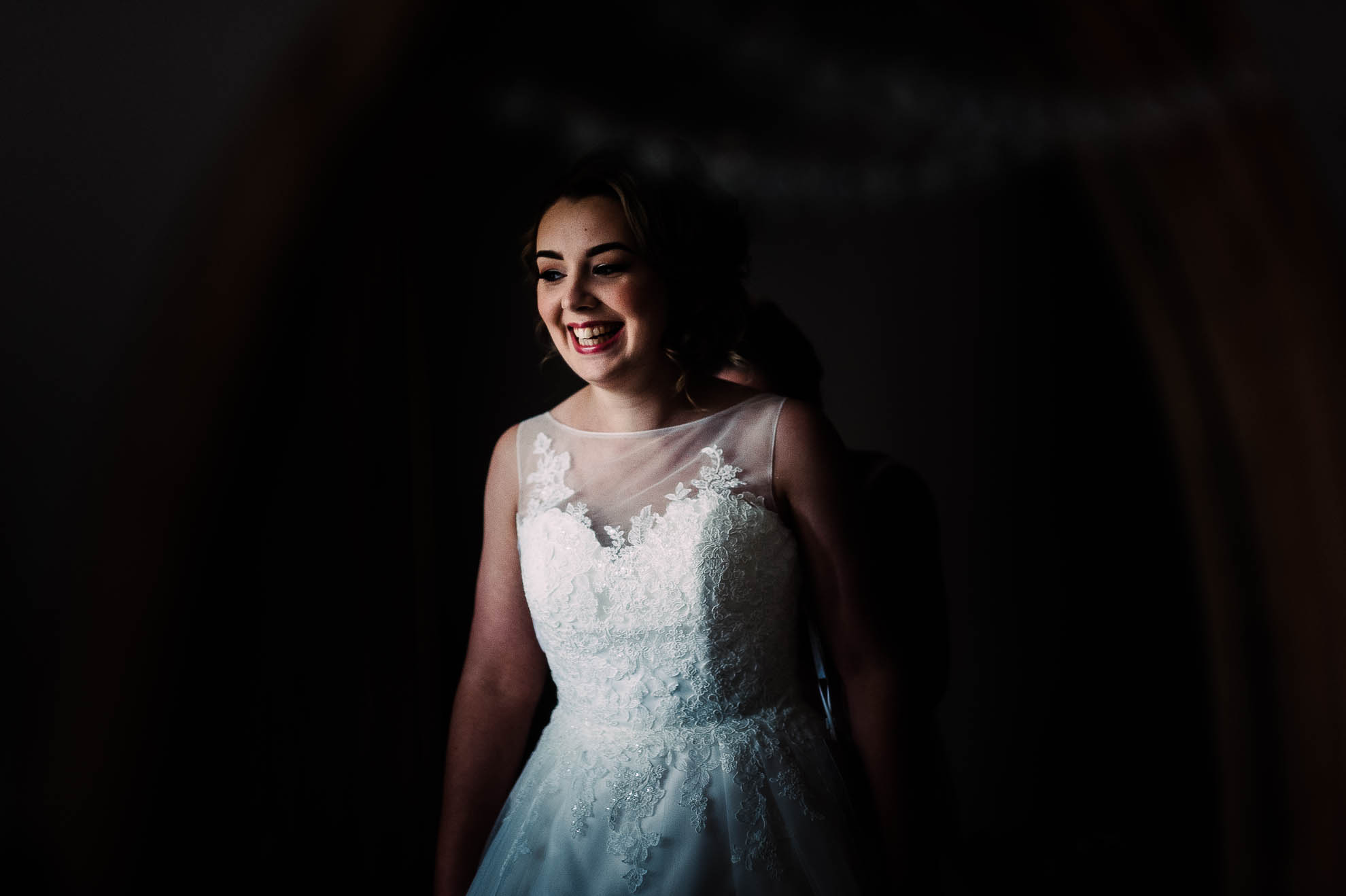 Bride reflection in mirror as she adjusts her wedding dress