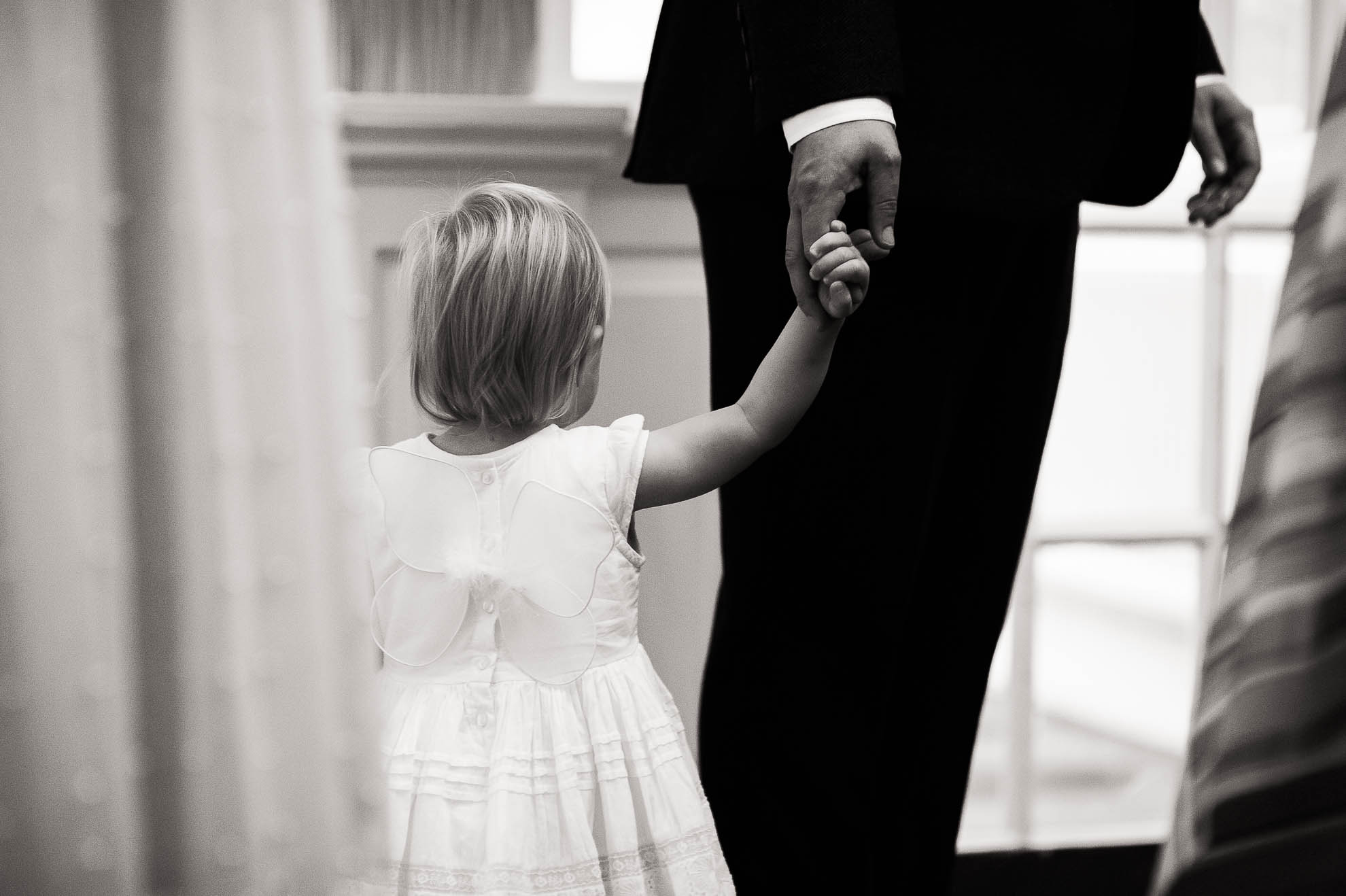 Little flower girl with her father the groom