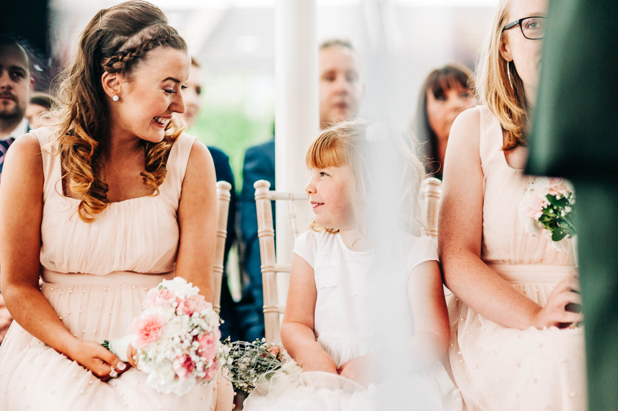 Bride and flower girl smile at each other