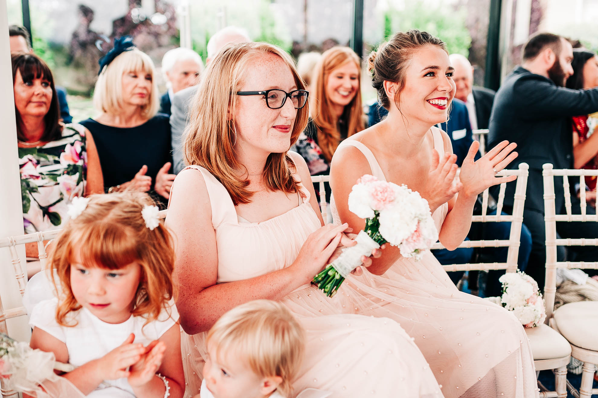 Bridesmaids clap the happy couple