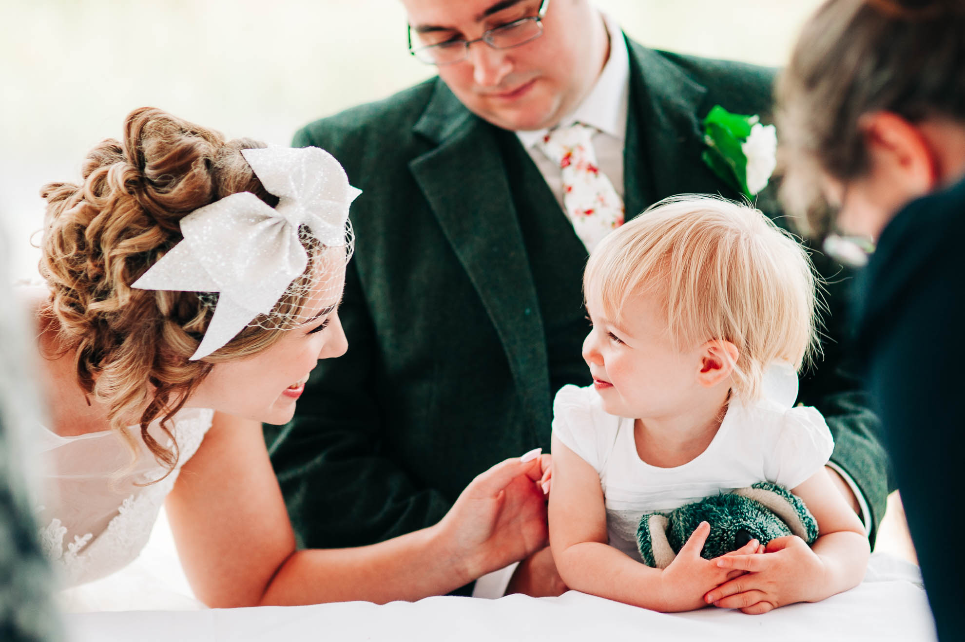 Bride and flower girl smile at each other