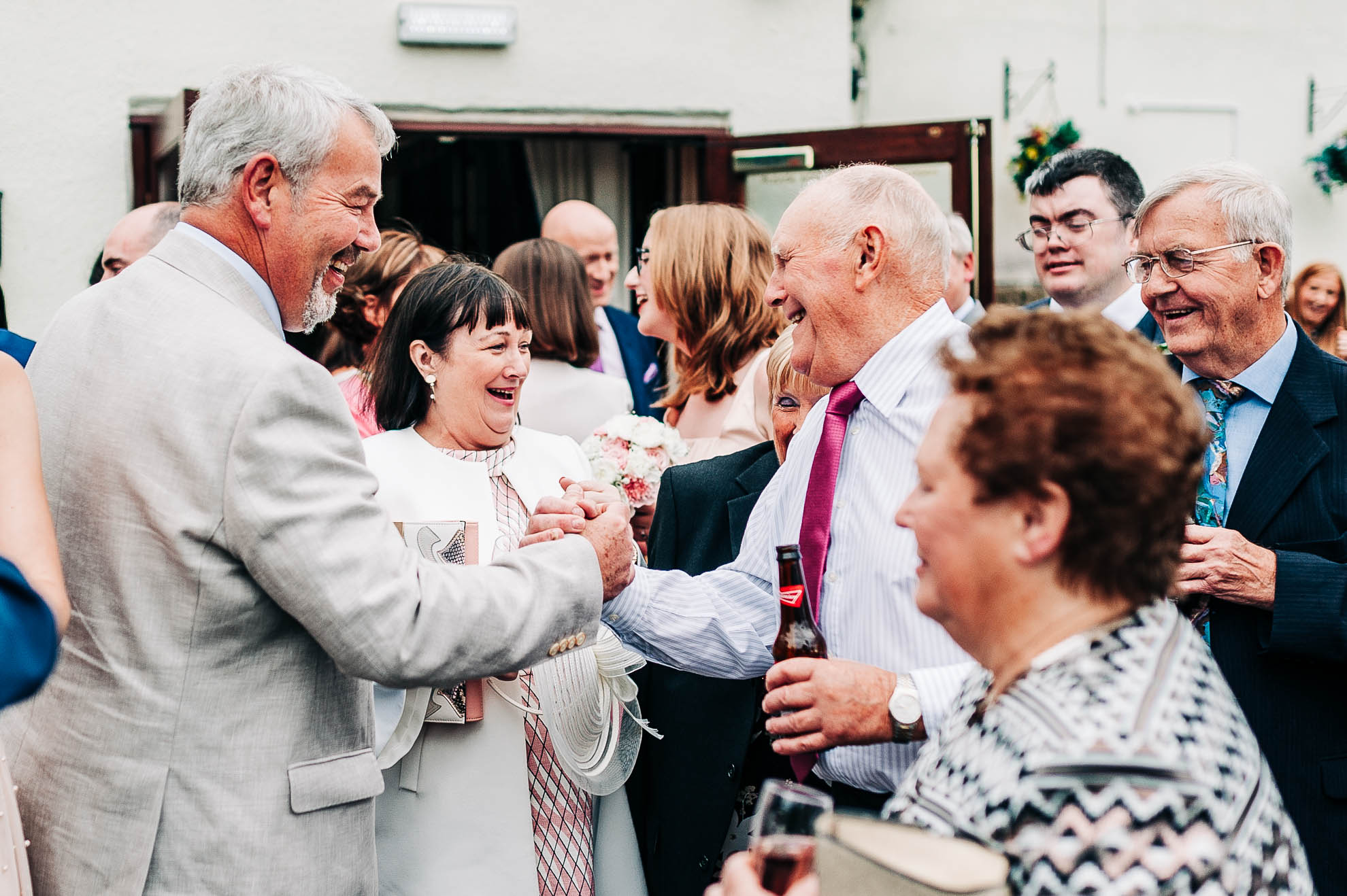 Father of the groom shakes hands with Grooms Family