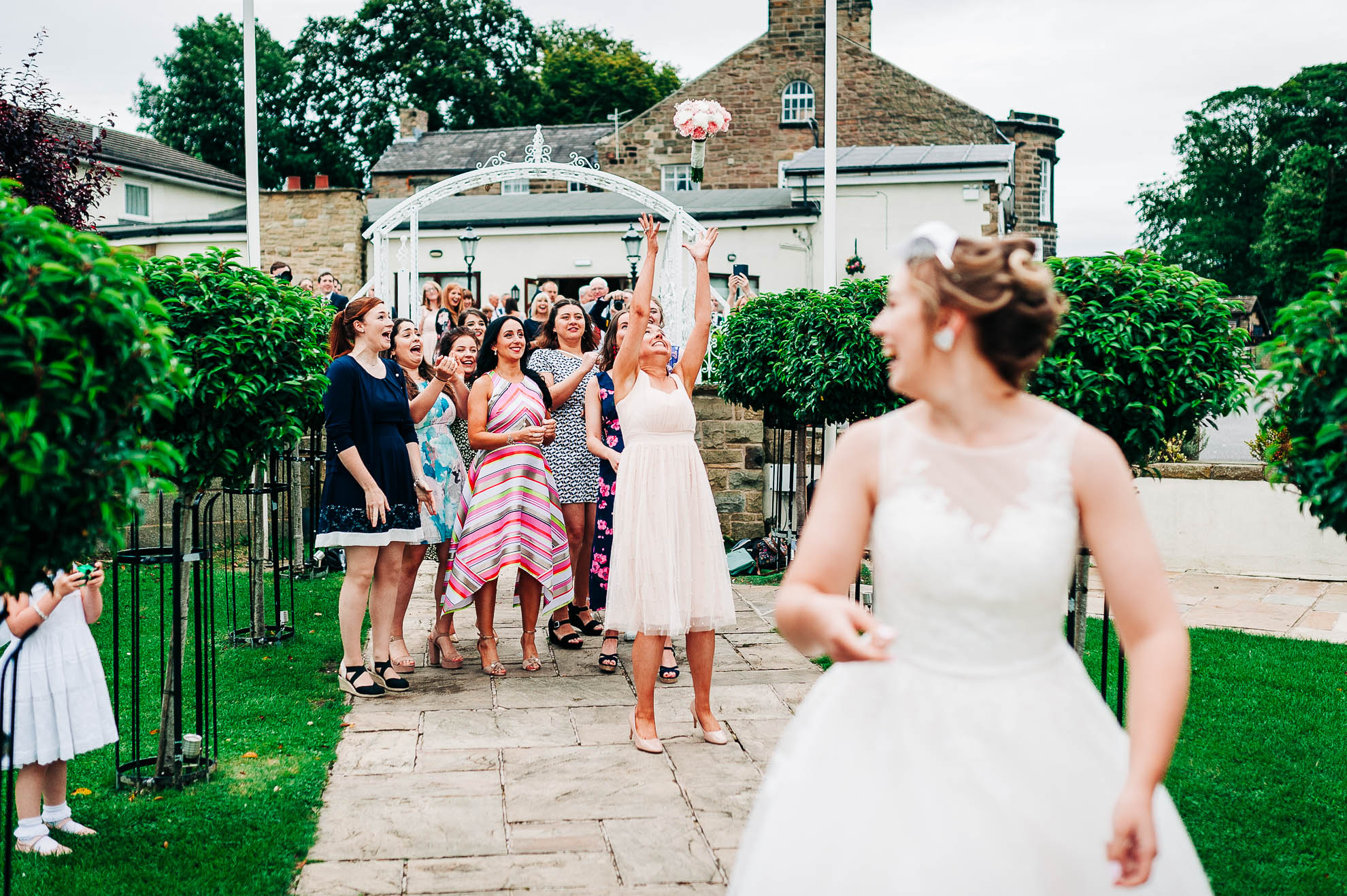 Bridesmaid catches the flowers in the bouquet toss