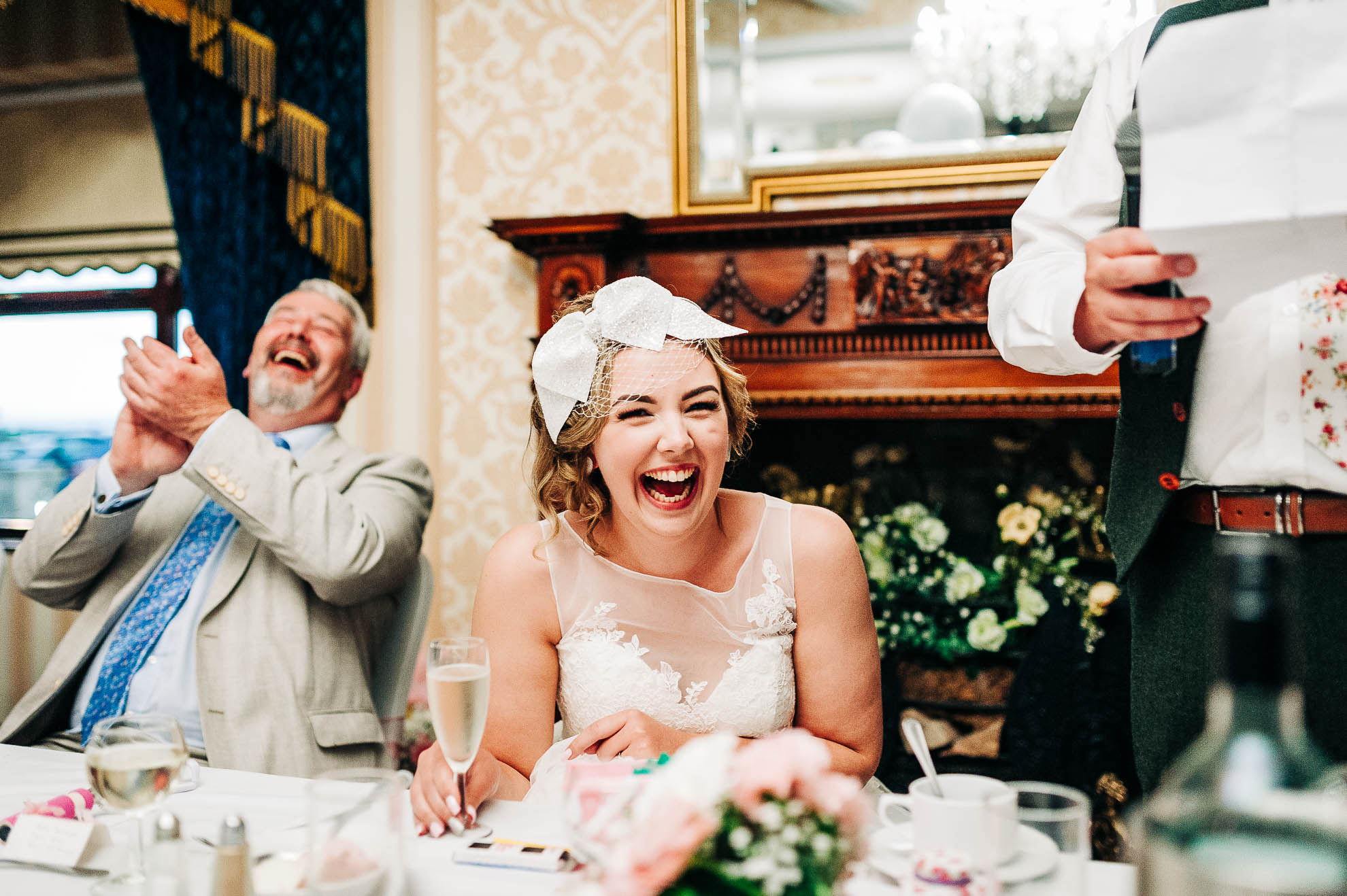 Bride laughs at Groom's joke during his speech