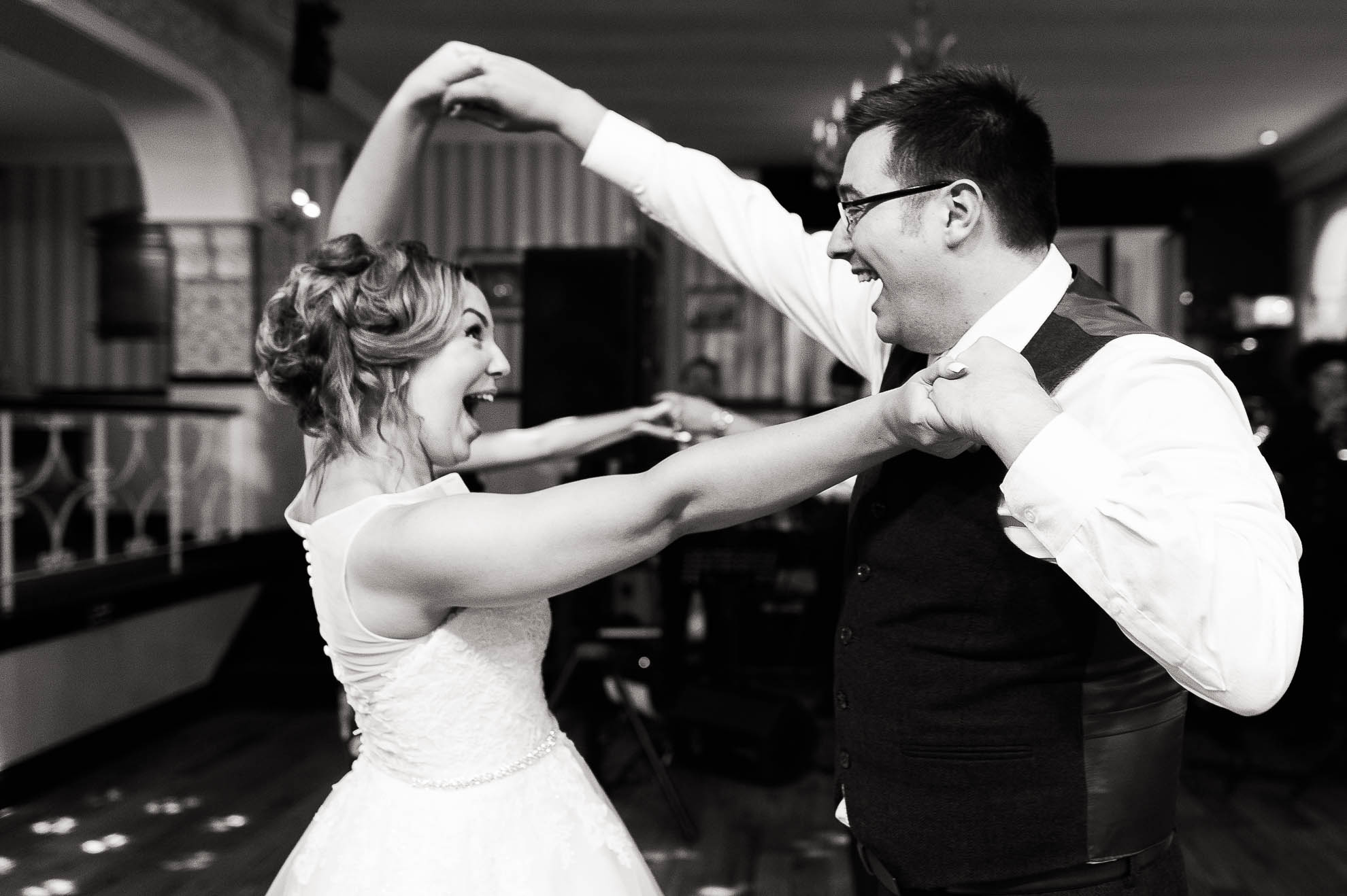 Bride and groom Laugh together as they dance