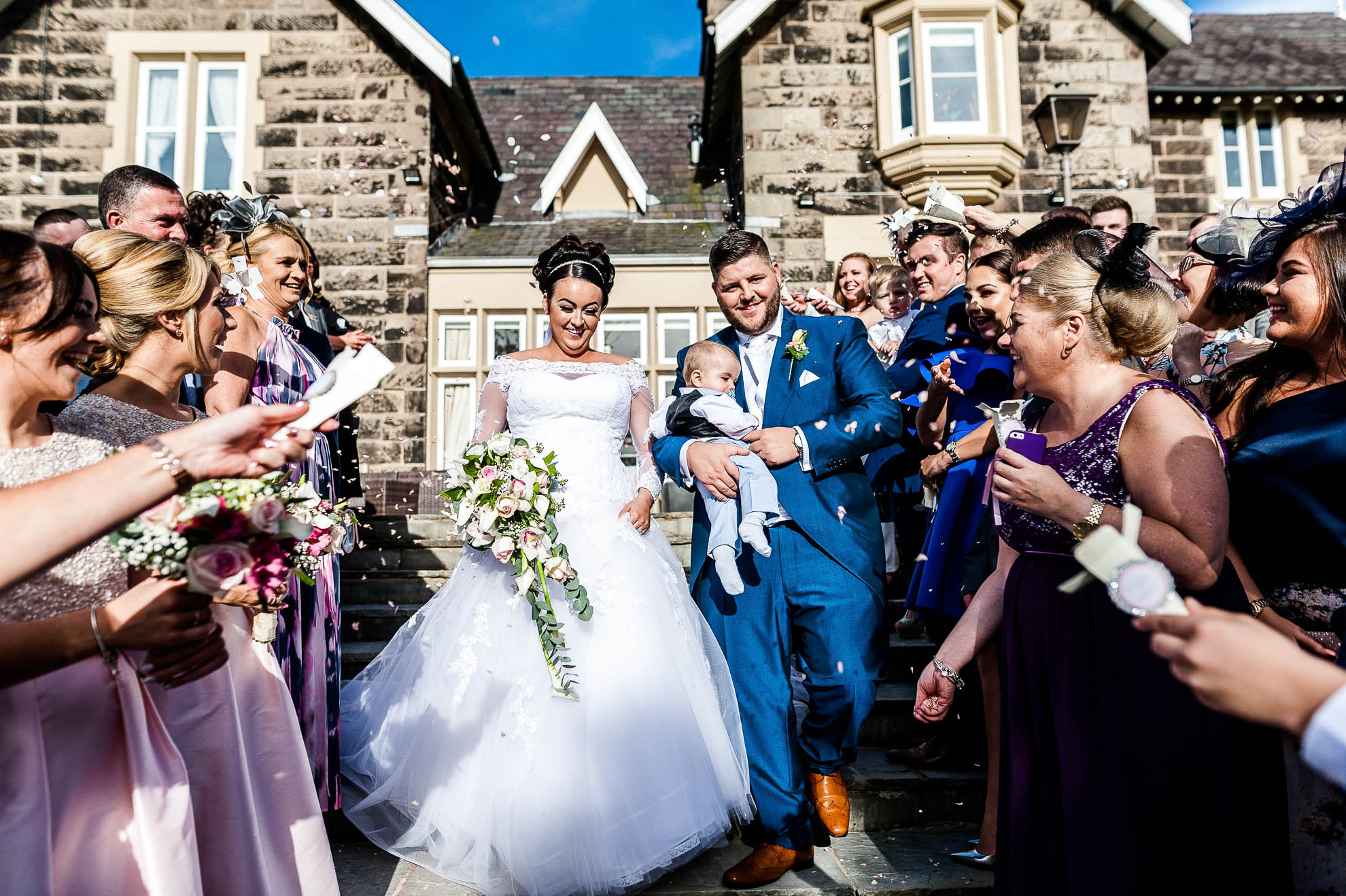 guests shower bride and groom with confetti