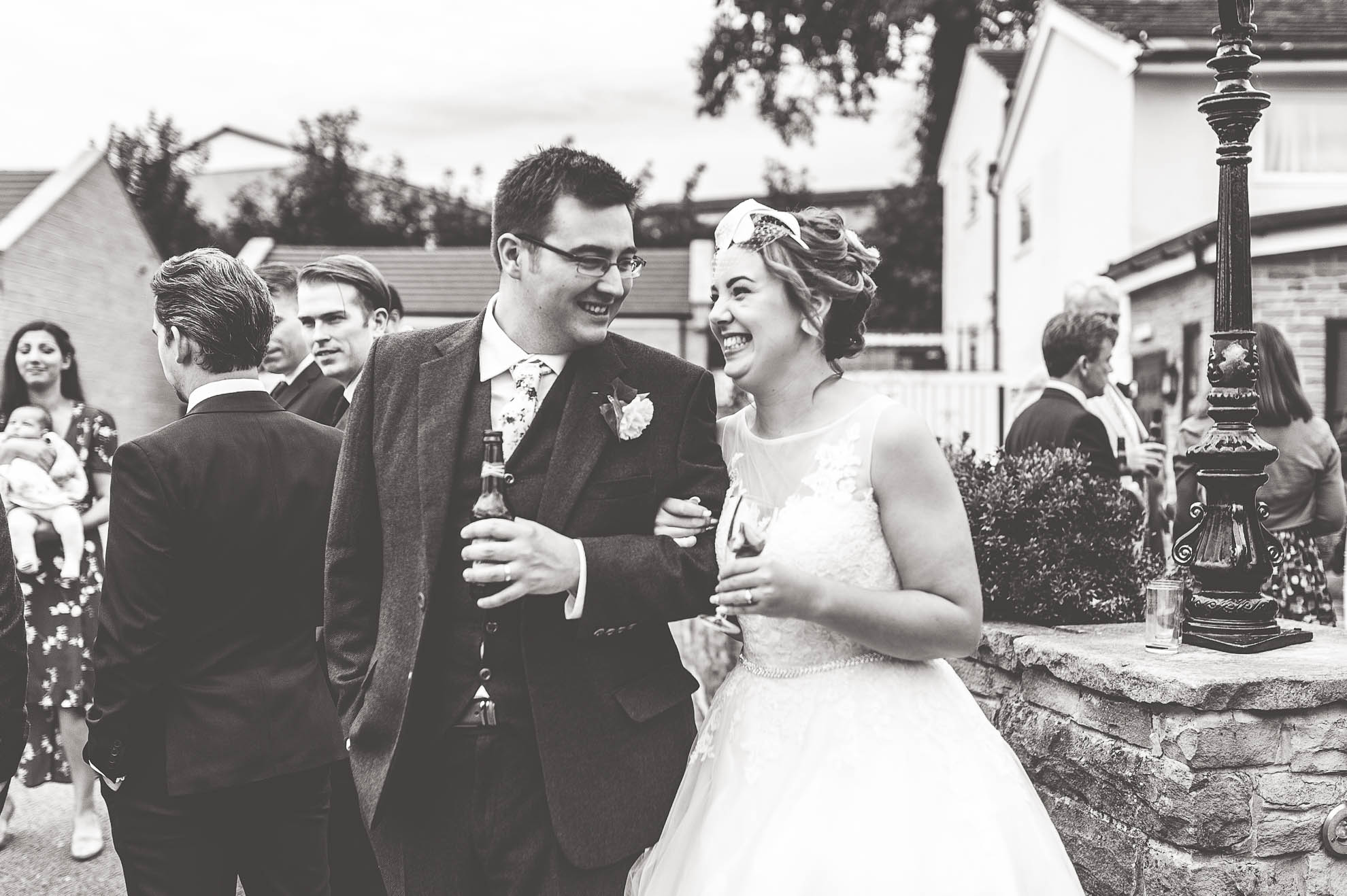Bride and groom share a joke during the drinks reception