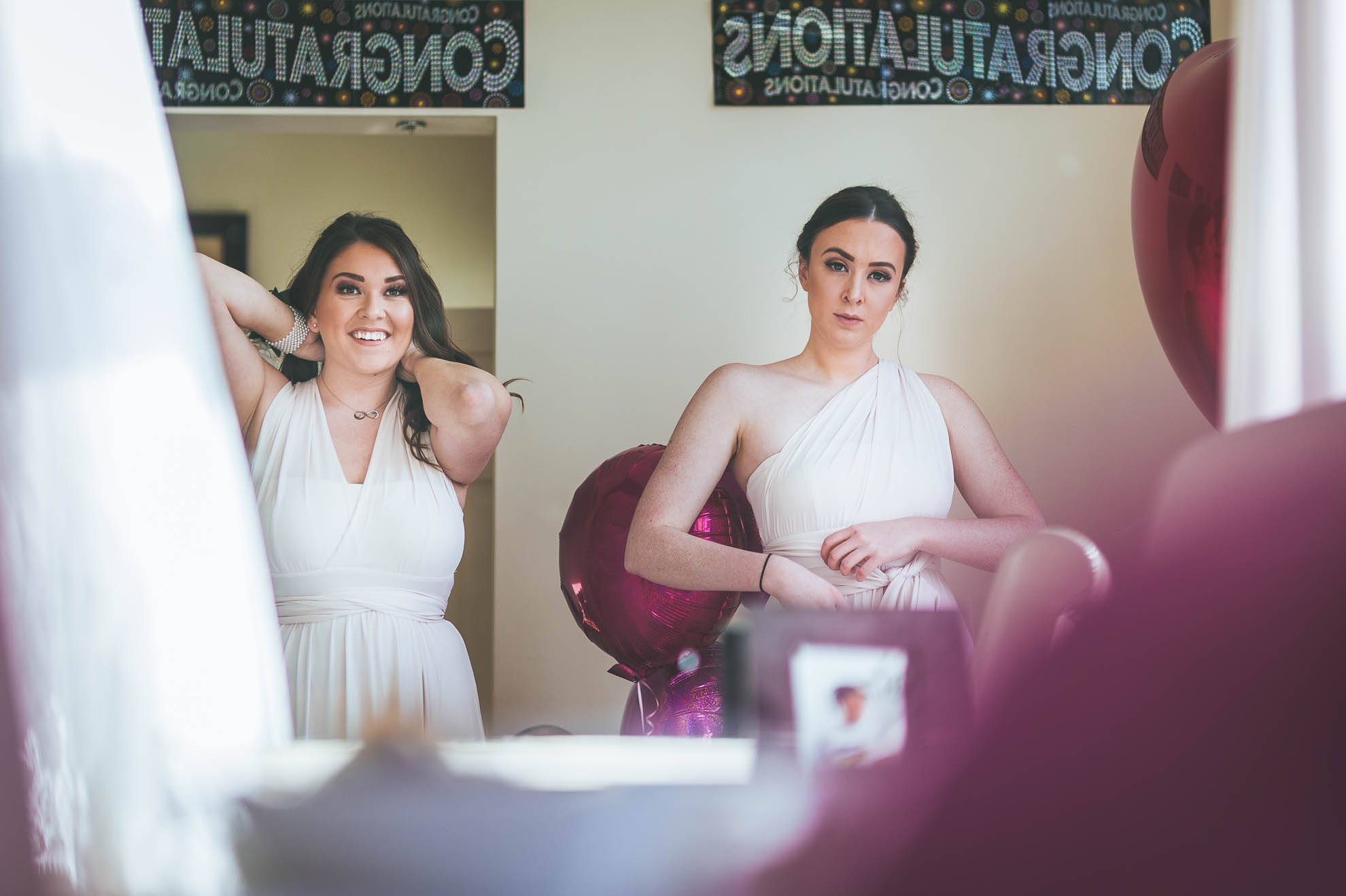 bridesmaids look in mirror getting ready