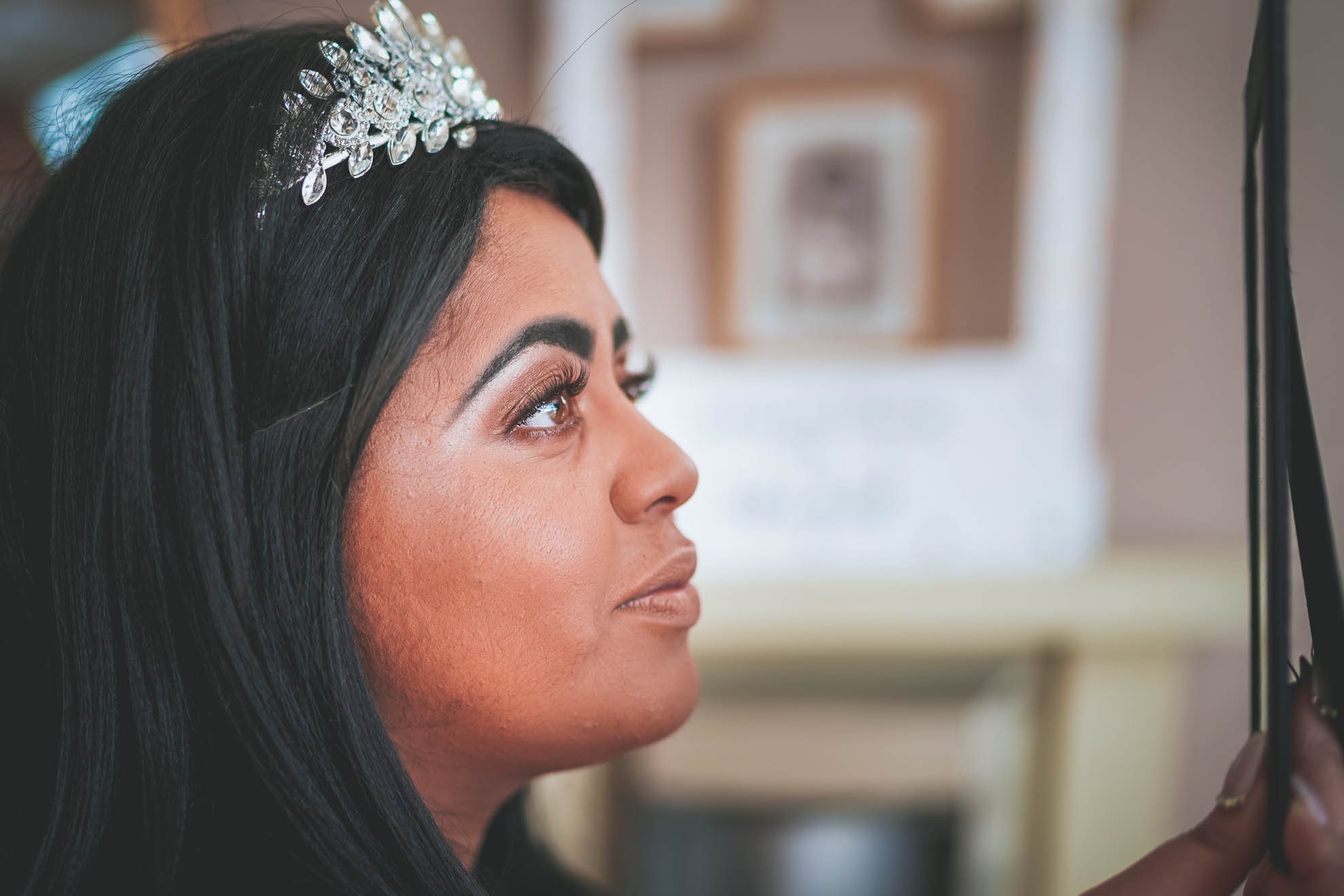 bride inspects her make up in the mirror