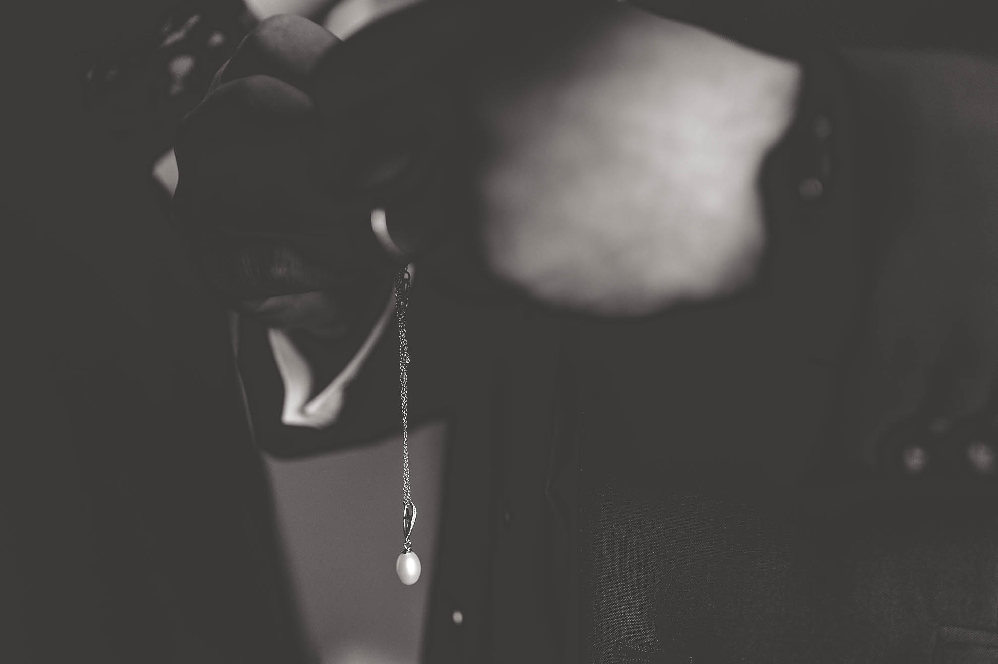 hands holding pendant