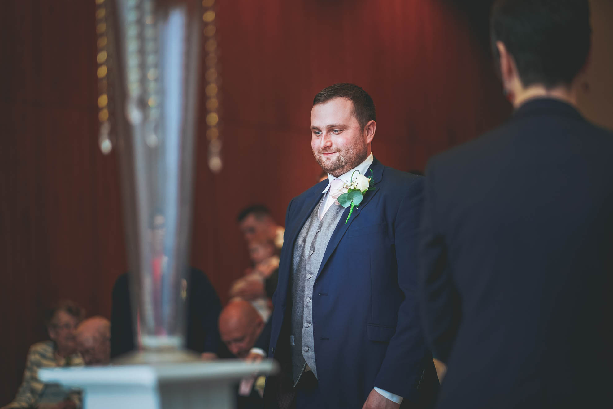 groom smiles as he waits for his bride