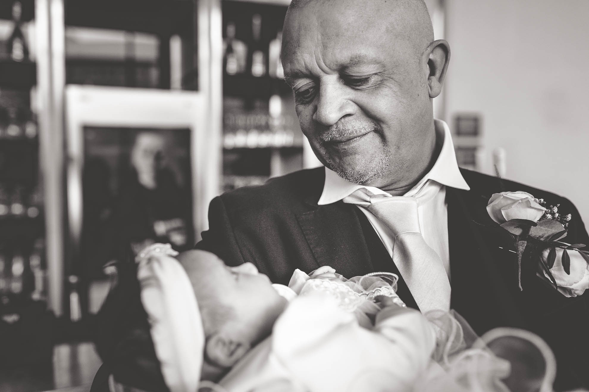 father of the bride holds his grandchild