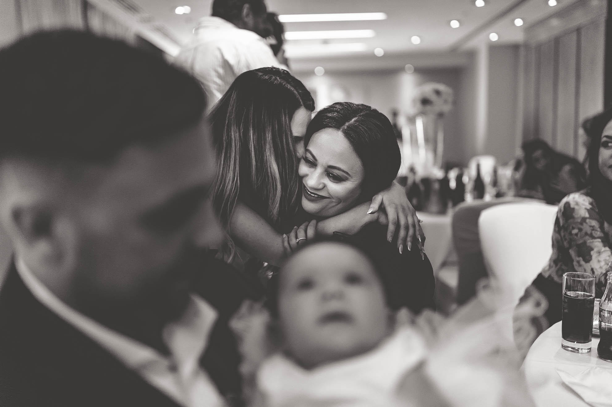 guest hugs bridesmaid
