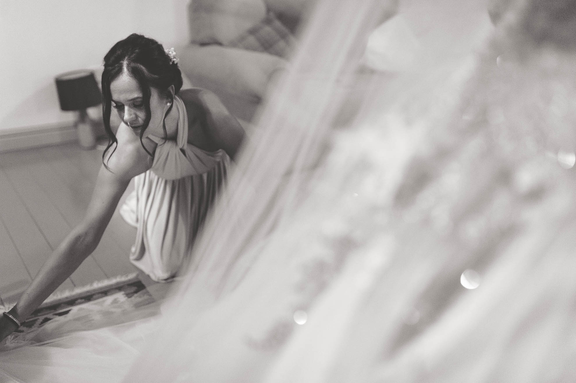 bridesmaid adjusts wedding dress