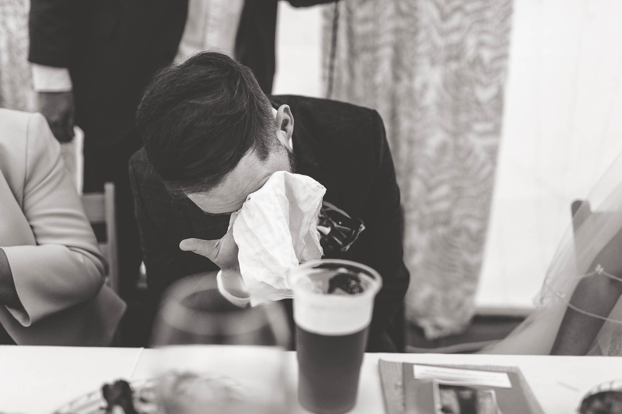Groom wipes a way a tear during speeches