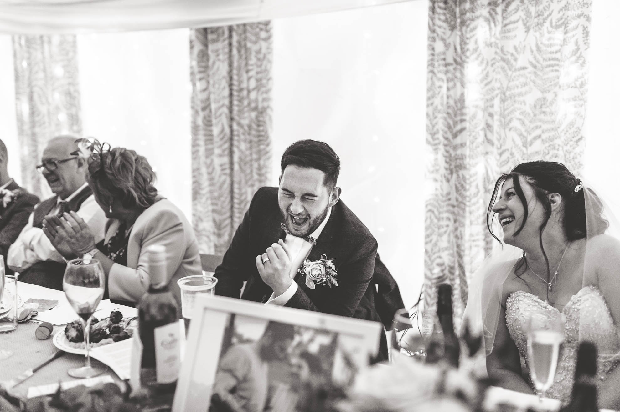 Bride and groom laugh at best mans joke